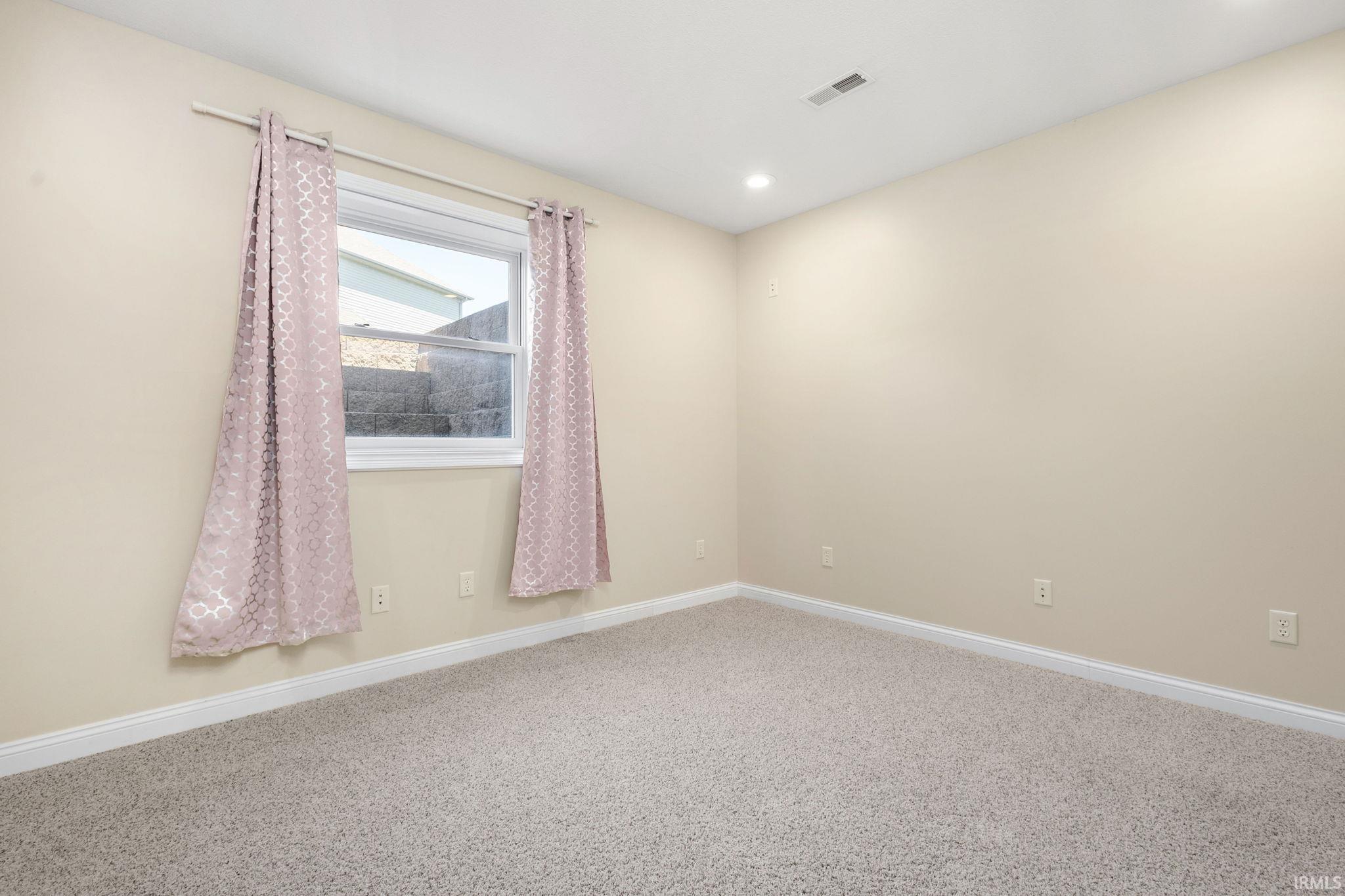 Carpeted room with a double-hung window, lower level