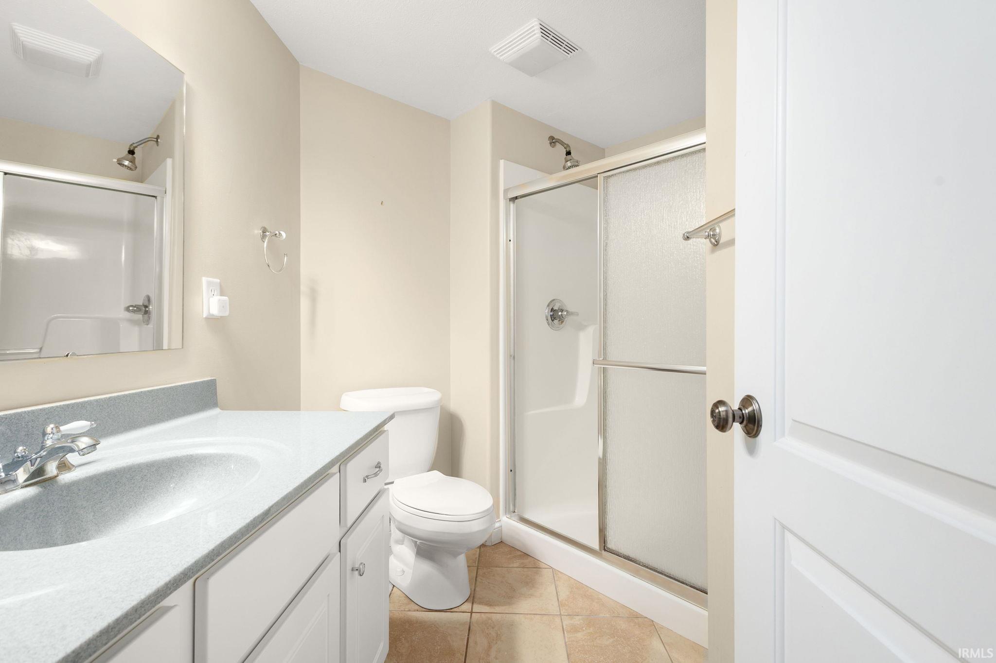 Bathroom featuring a white vanity with integrated sink, light-toned countertop, and chrome fixtures. Lower level