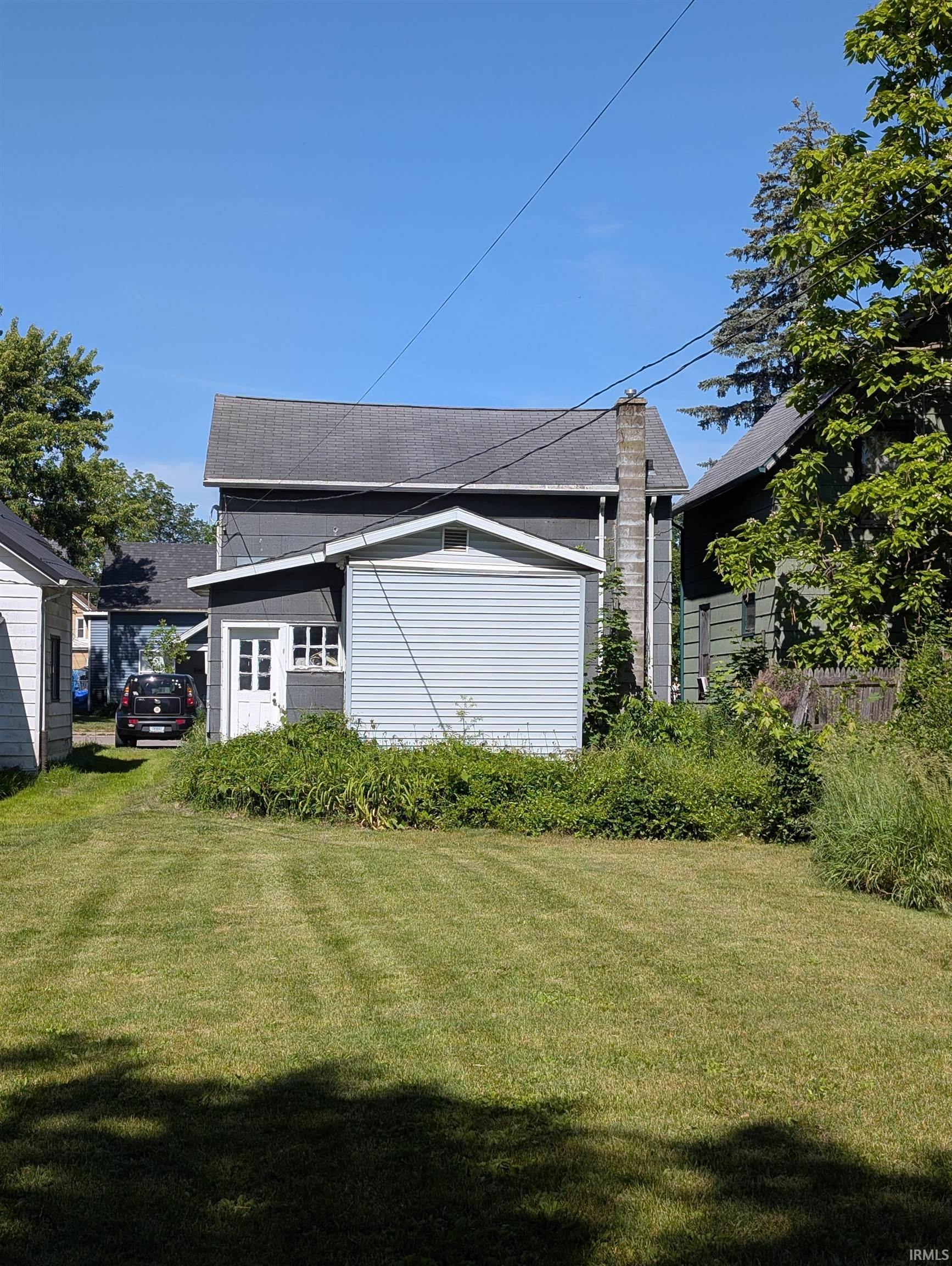 Rear exterior showcasing a two-story structure with dark gray siding and a light gray roof