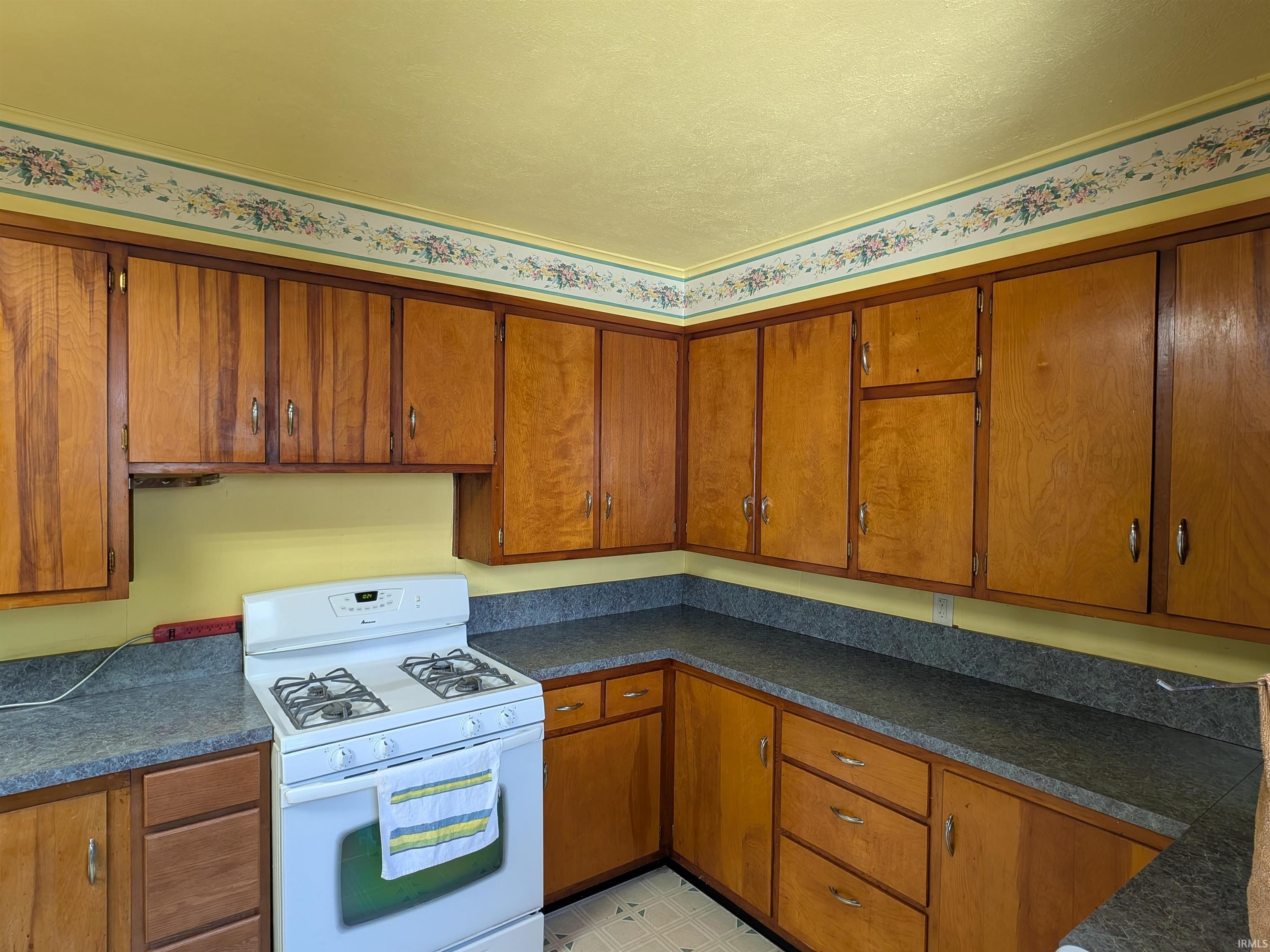 Kitchen featuring extensive wood cabinetry, laminate countertops, and a built-in range
