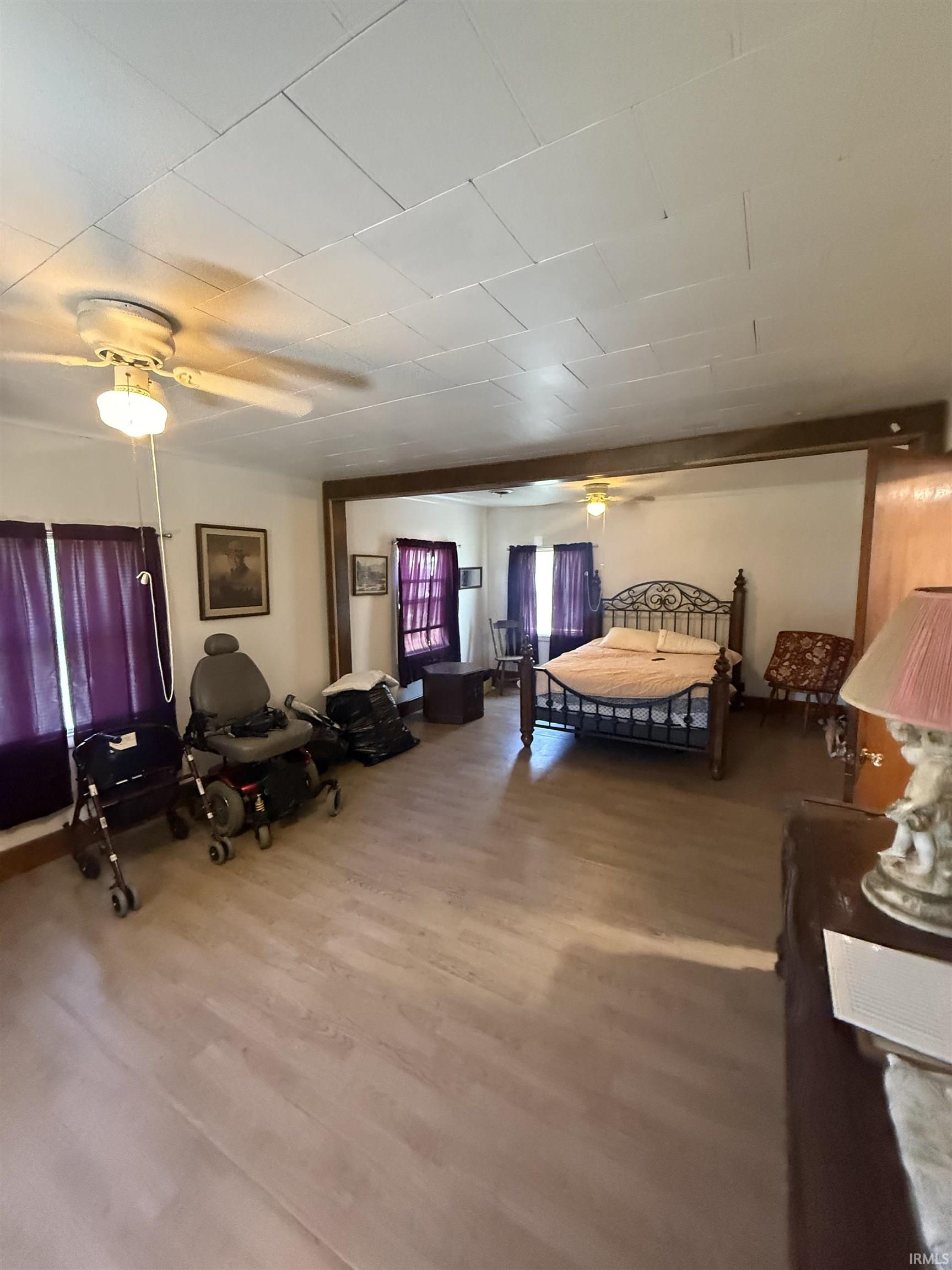 Spacious room featuring wood-finish flooring, white paneled ceilings, and recessed lighting