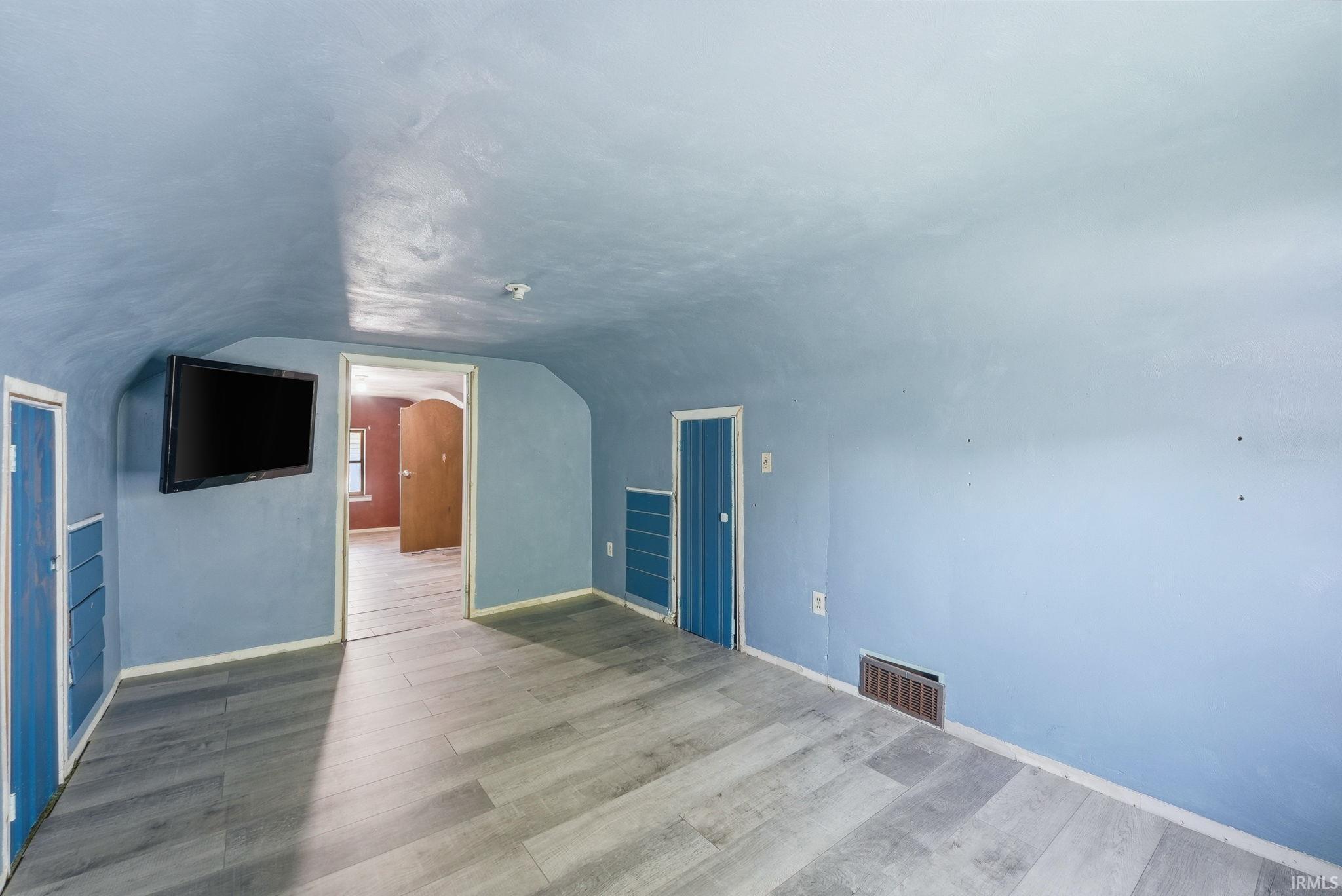 Room with light blue walls and wood-finish flooring