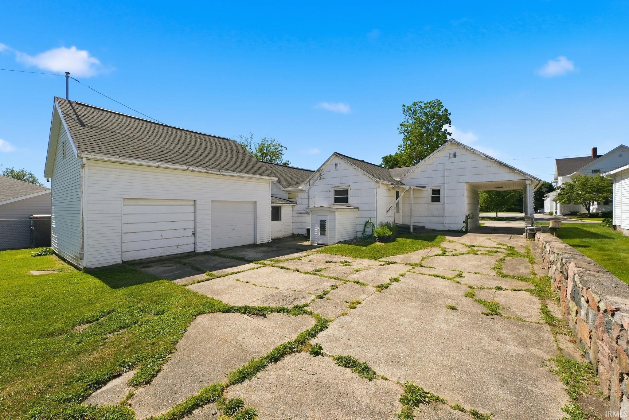 Two-car garage with white siding and gray shingle roofing