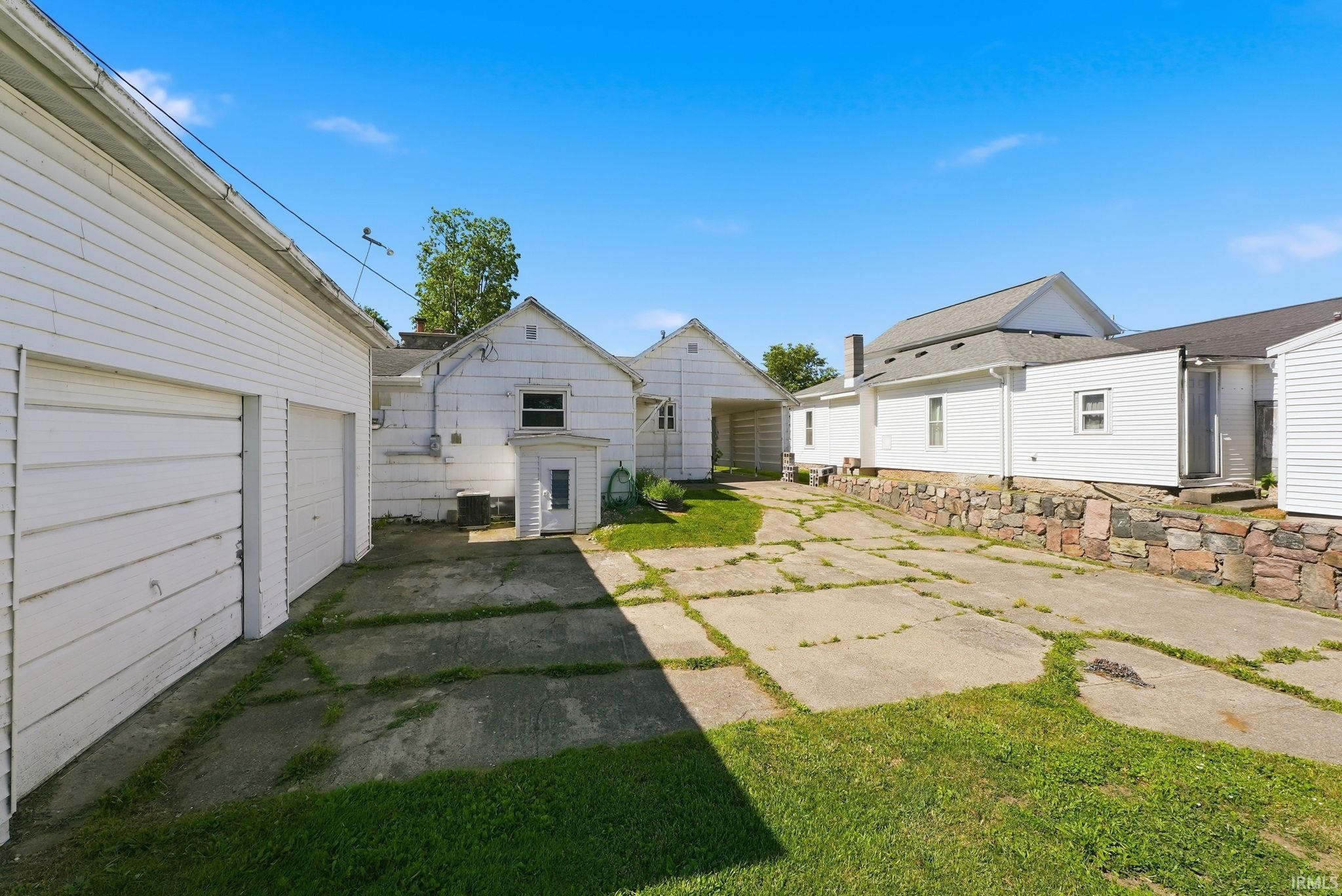 Expansive concrete paved area with two separate garage structures