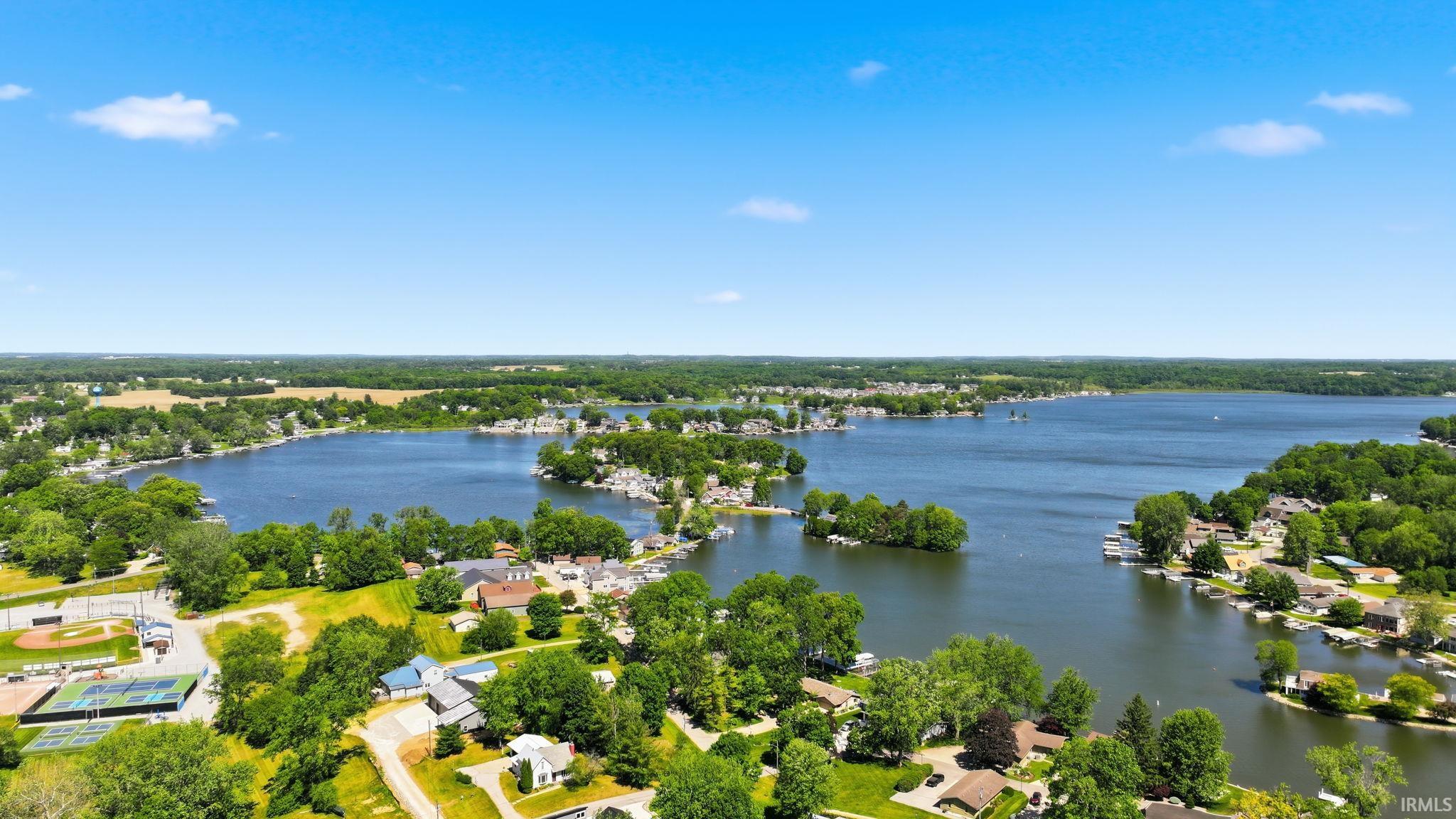 Expansive lake with multiple islands, surrounded by residential properties and mature trees