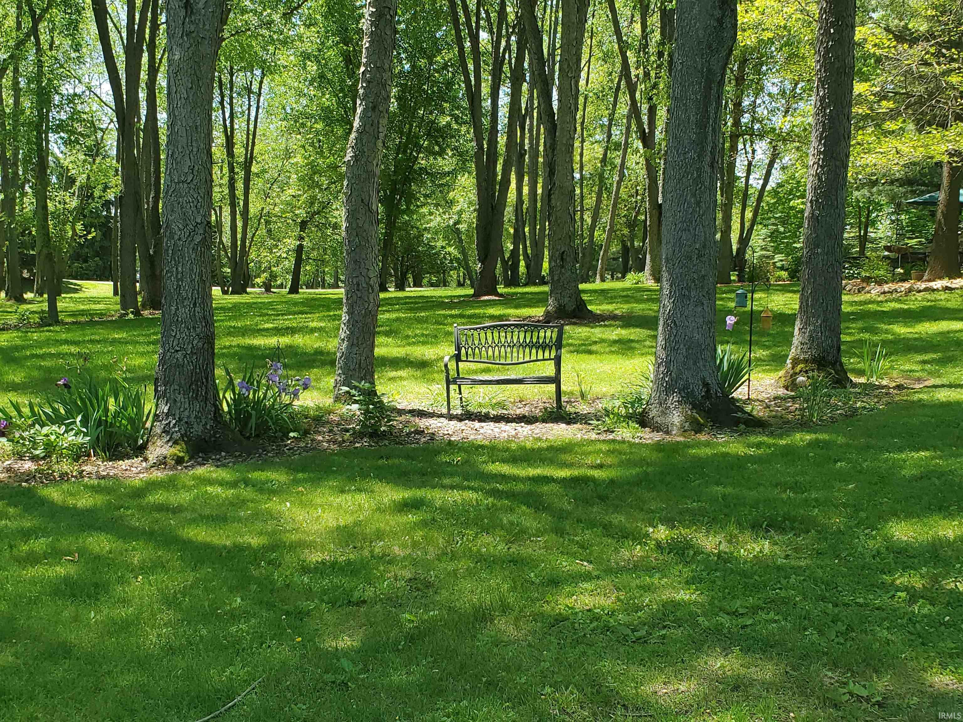 Expansive outdoor grounds featuring mature trees and a manicured lawn