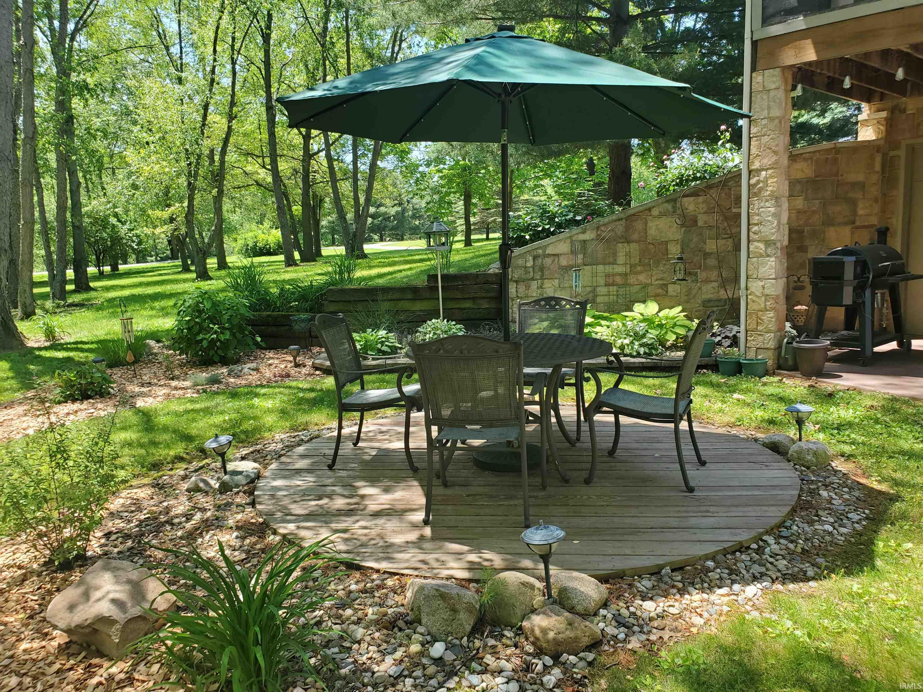 Circular wood deck patio surrounded by decorative rock landscaping
