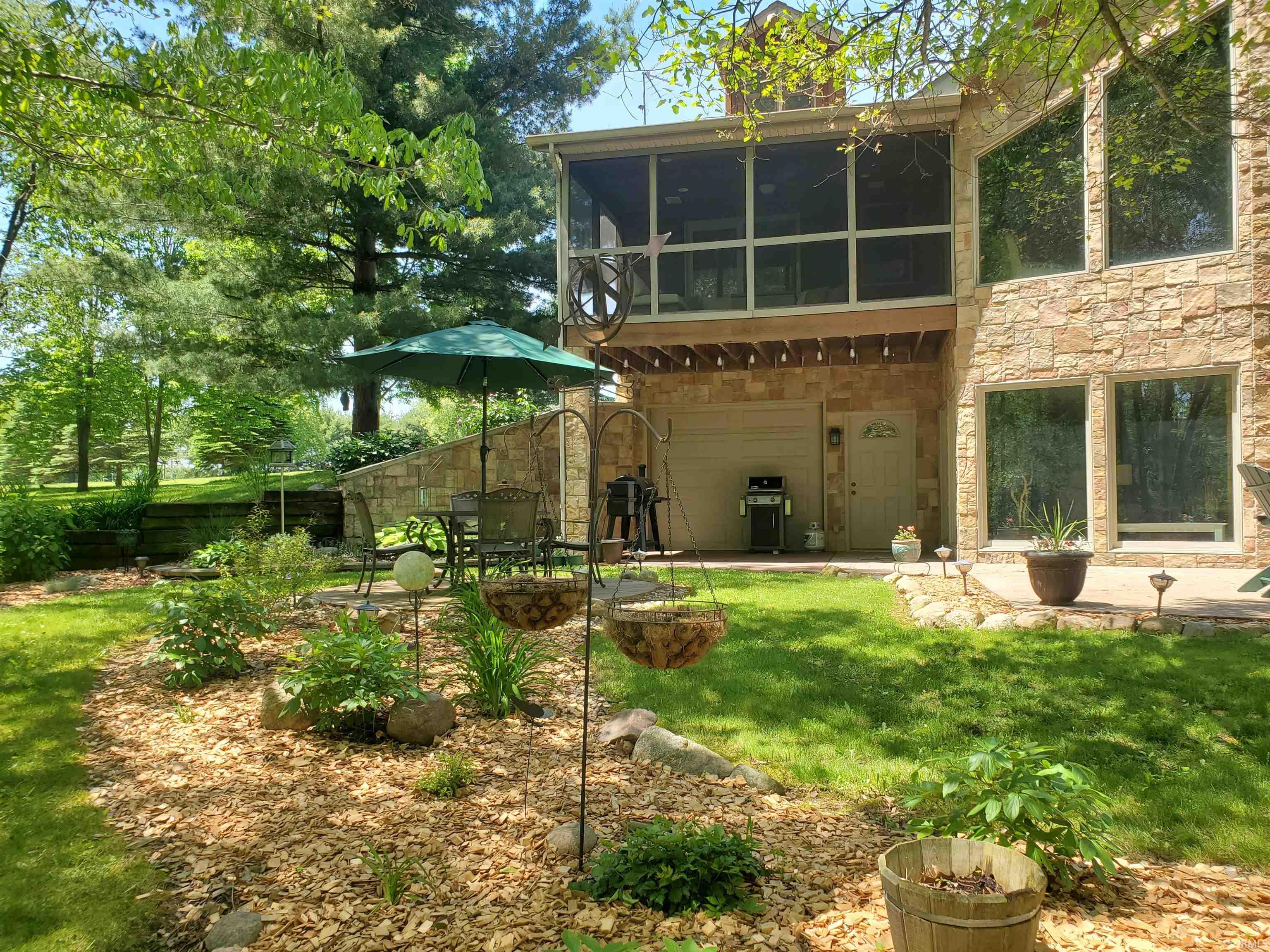 Stone veneer exterior featuring a screened-in porch and large windows
