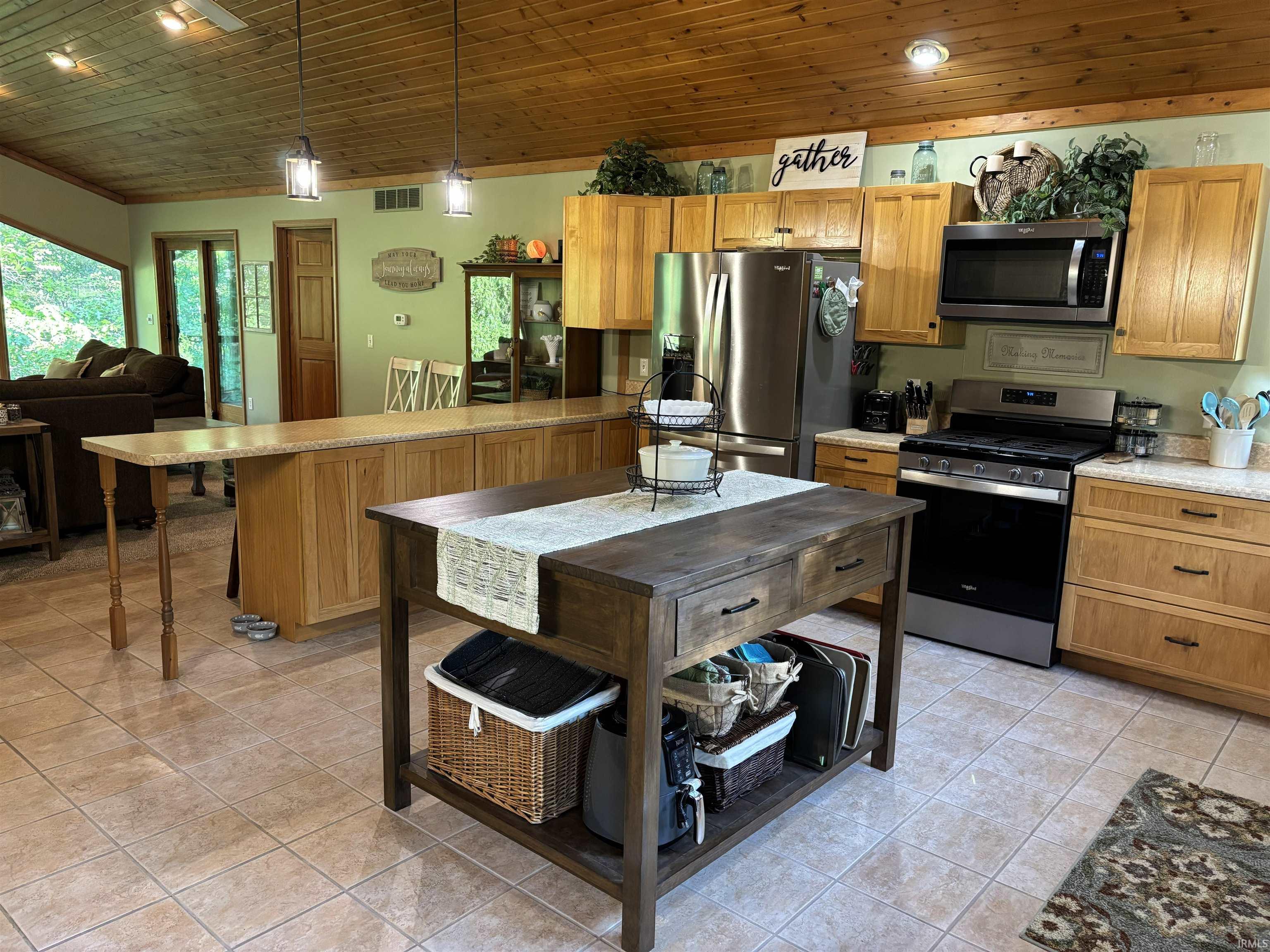 Kitchen featuring wood-finish cabinetry, tile flooring, and a large central island