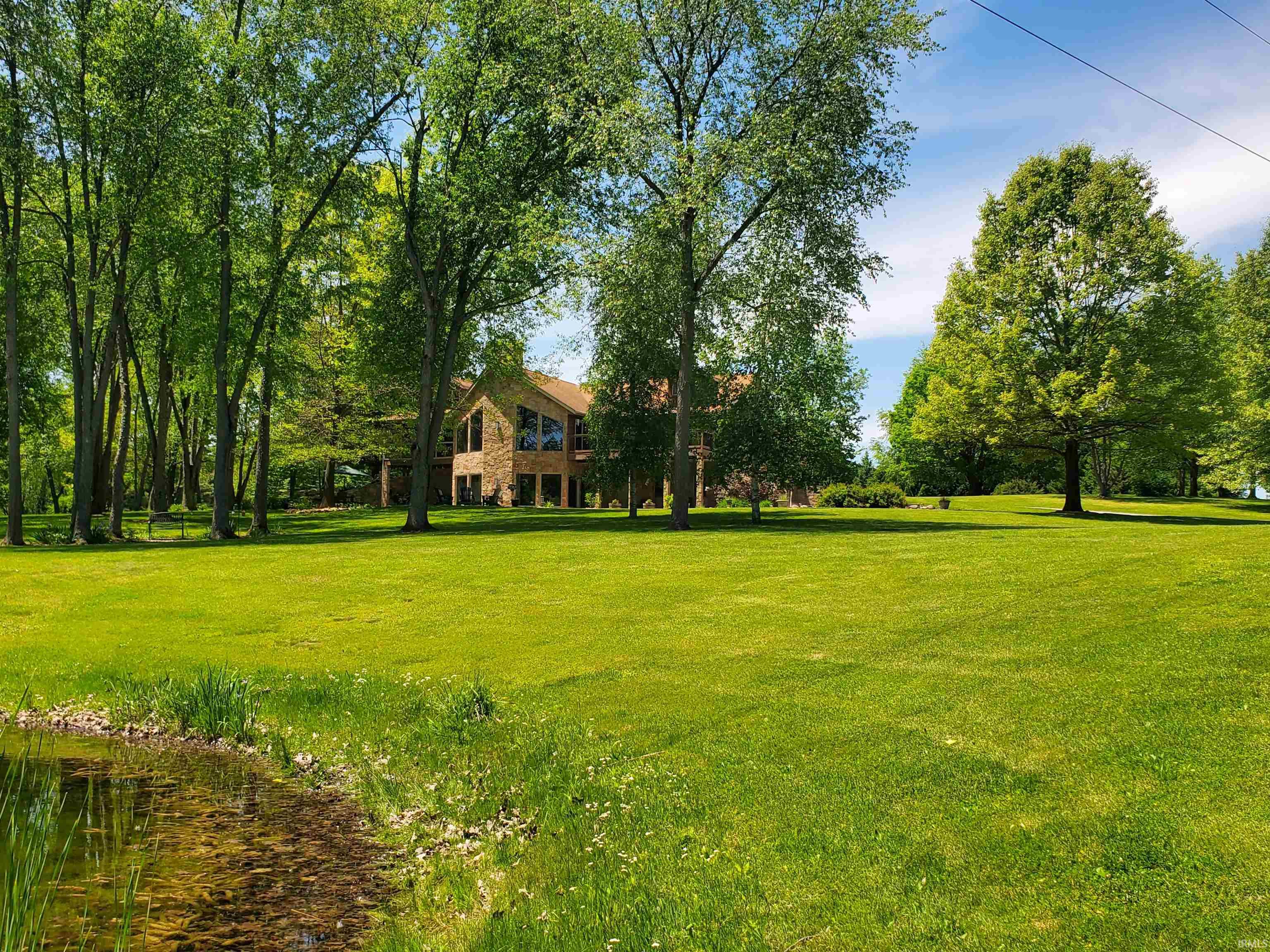 Expansive green lawn with a natural pond feature