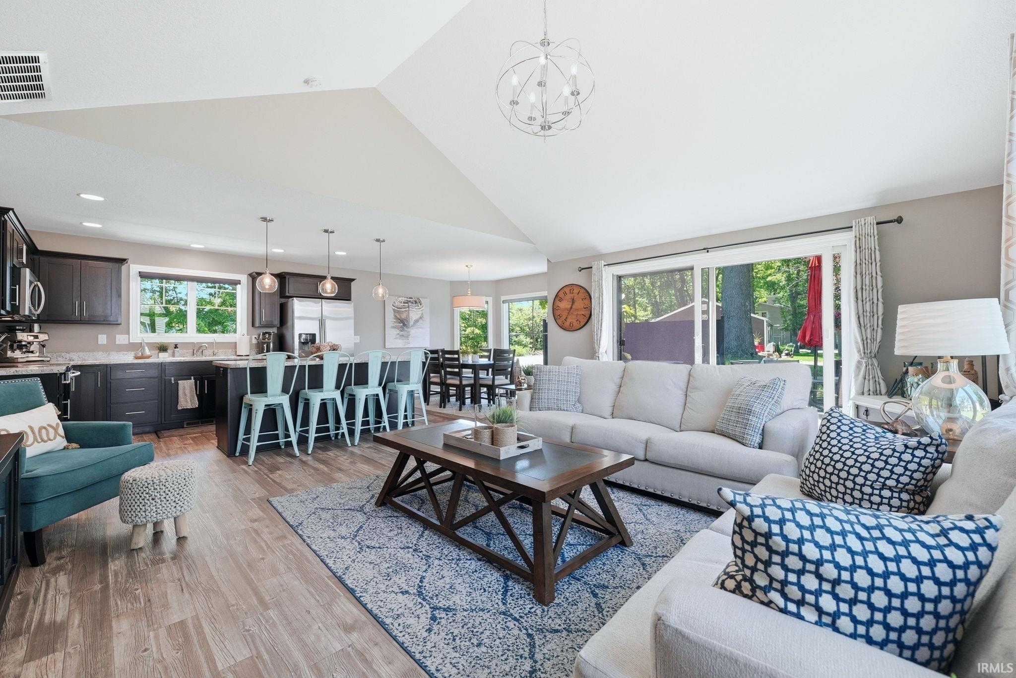 Open-concept living space featuring wood-finish flooring and a vaulted ceiling
