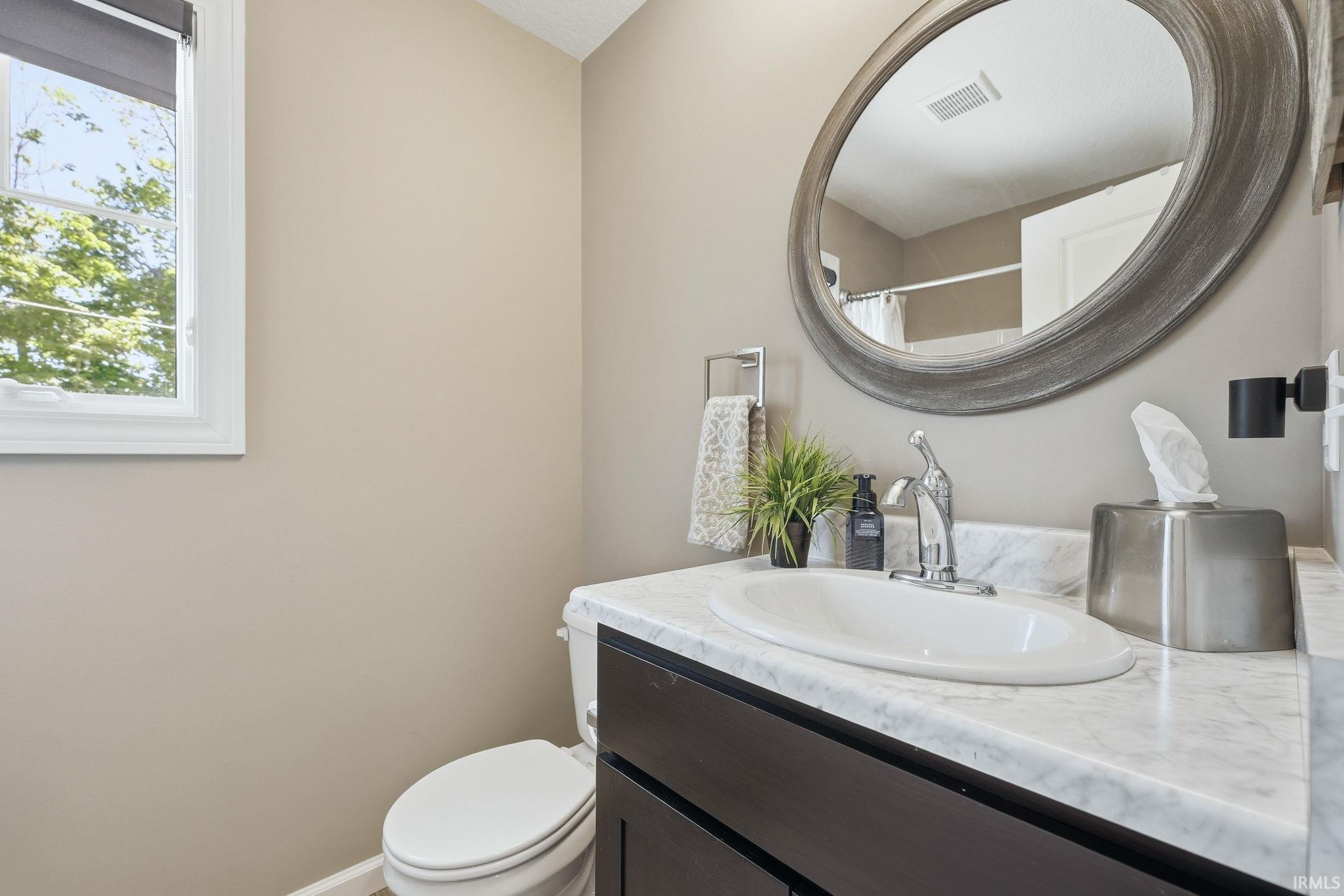 Bathroom featuring a single vanity with a white countertop and integrated sink