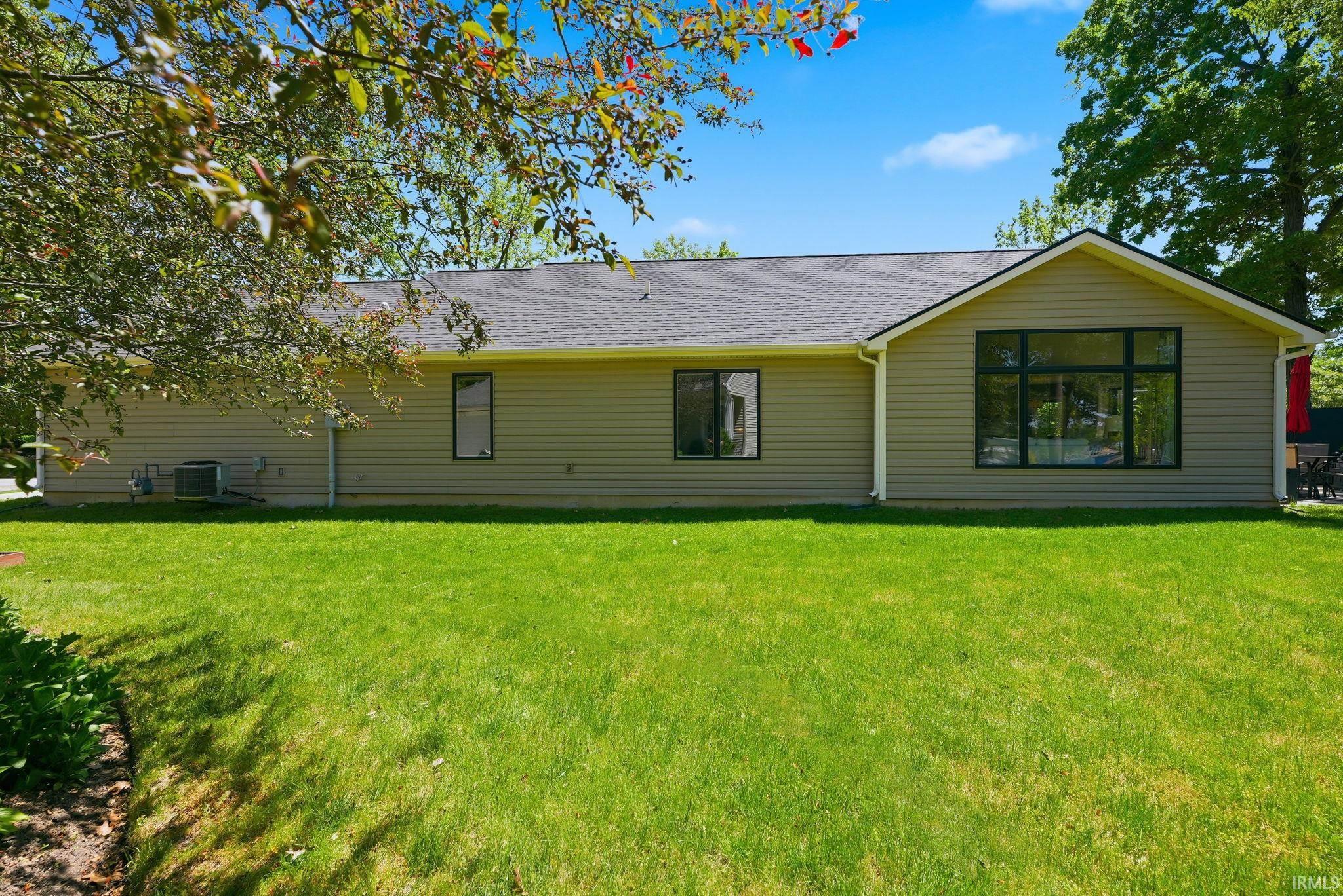 Expansive rear yard featuring green lawn