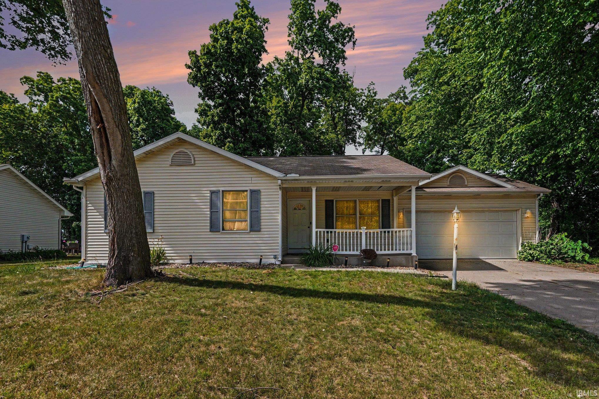Light-colored siding exterior with a covered front porch featuring white railings
