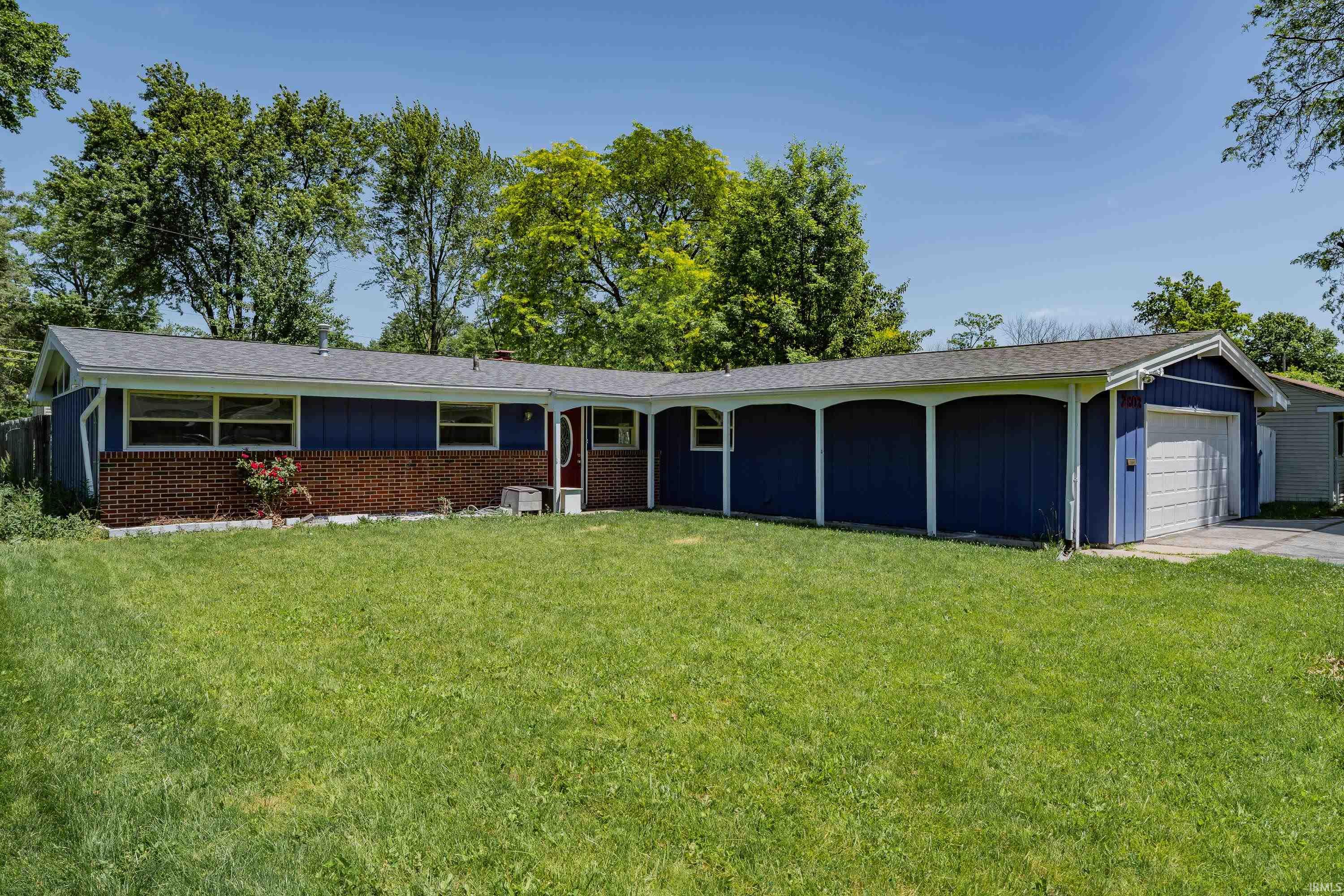 Single-story residence featuring a blue painted exterior with a contrasting brick facade and a gray shingled roof