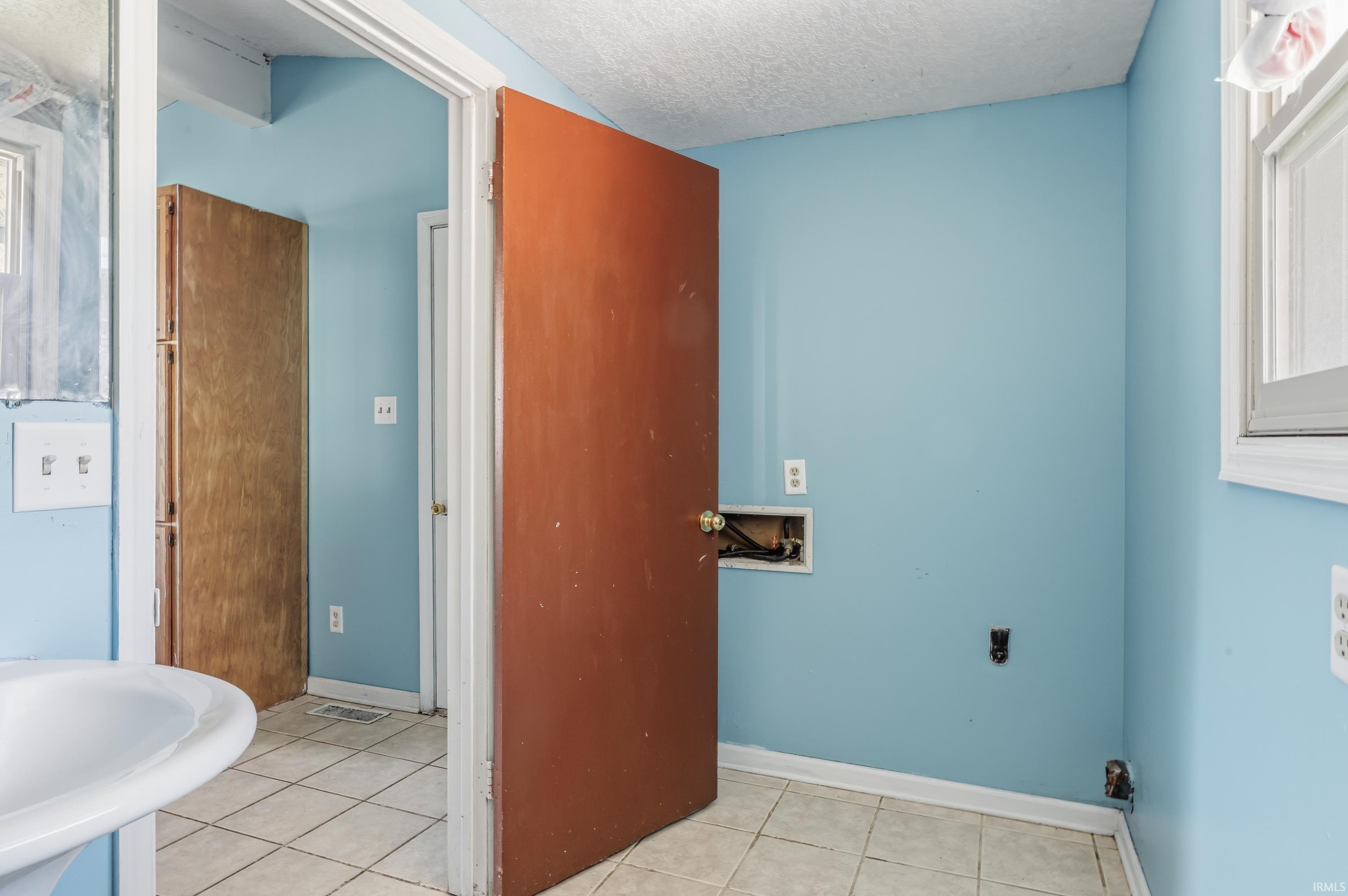 Ceramic tile flooring features throughout this bright room with light blue walls