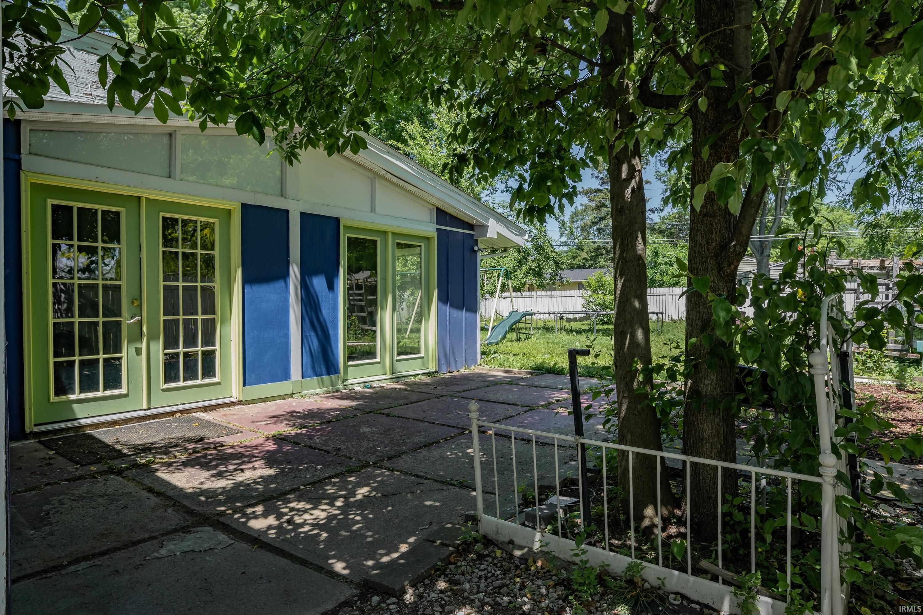 Blue exterior siding with light green trim and dual glass-paned doors