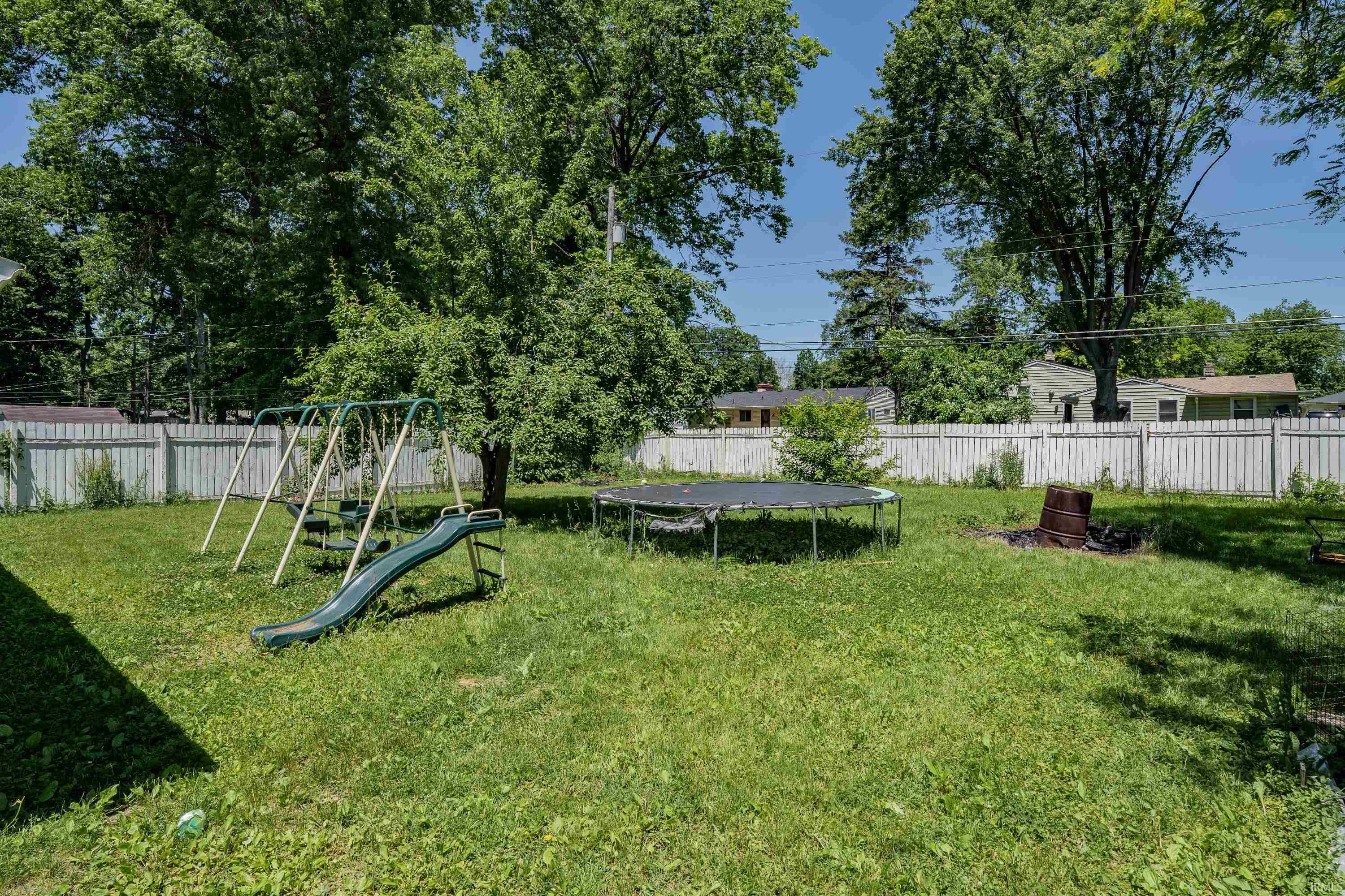 Expansive green lawn surrounded by a white privacy fence