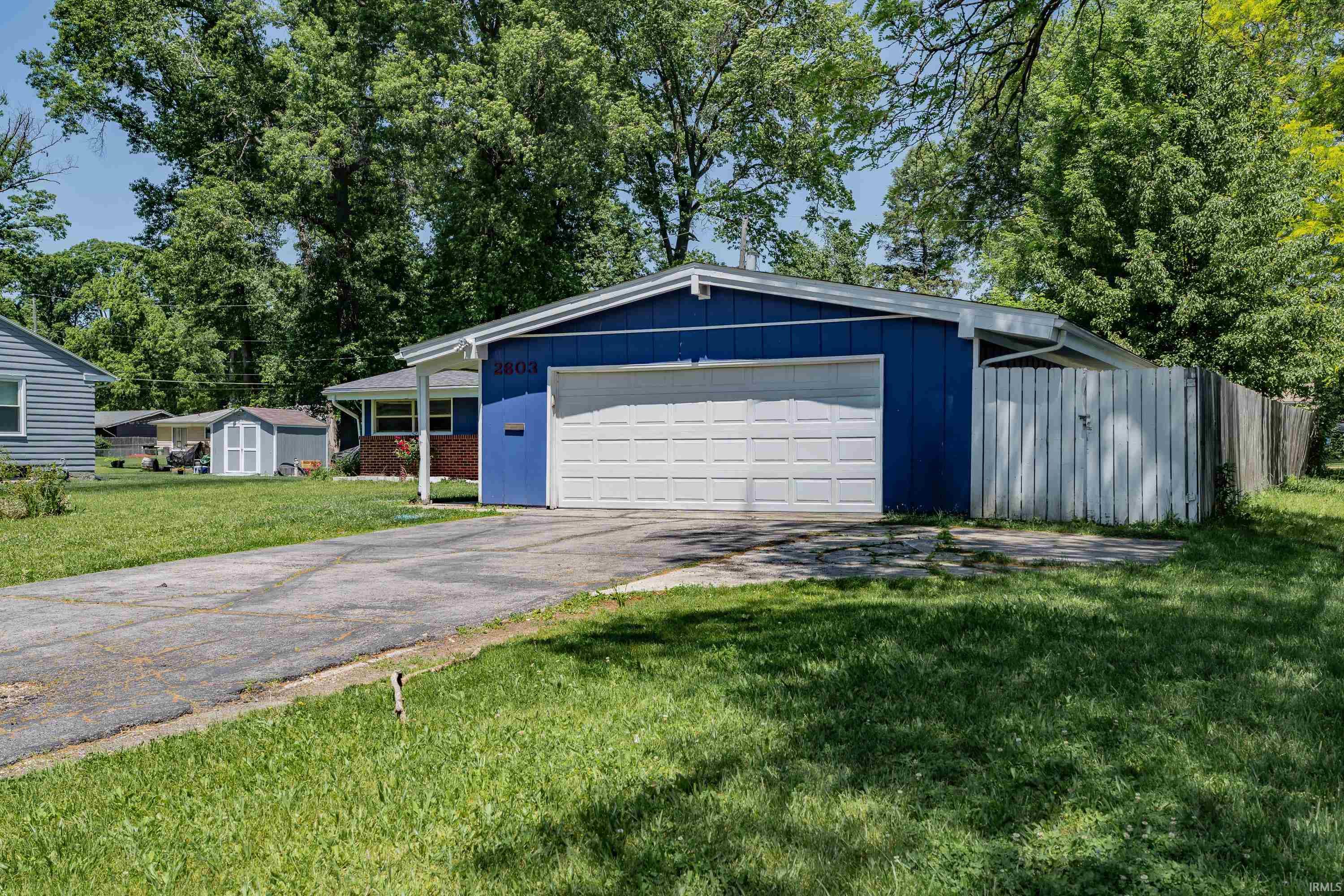 Ranch-style exterior with blue siding and a white garage door
