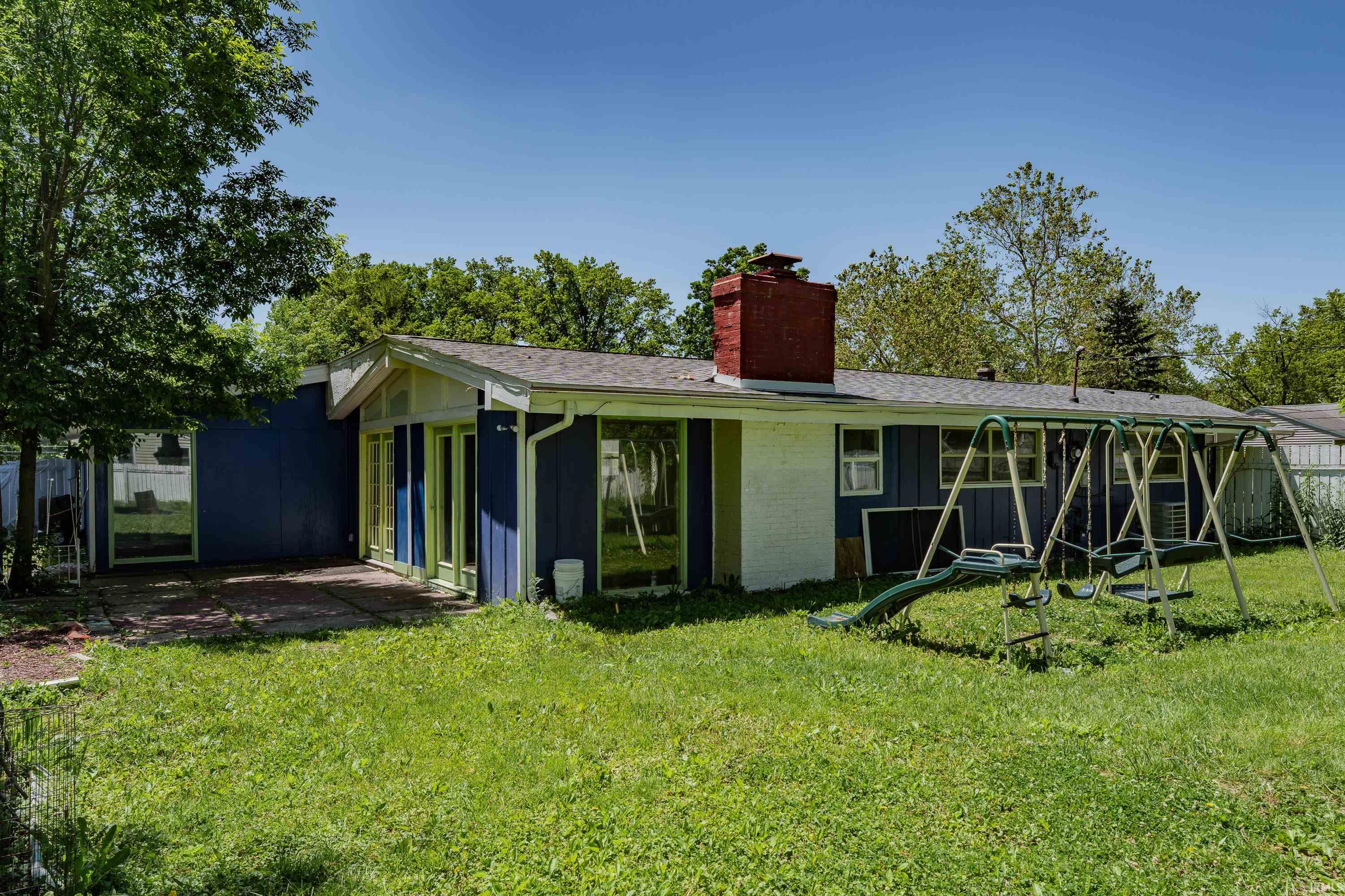 Expansive backyard with a green lawn and mature trees