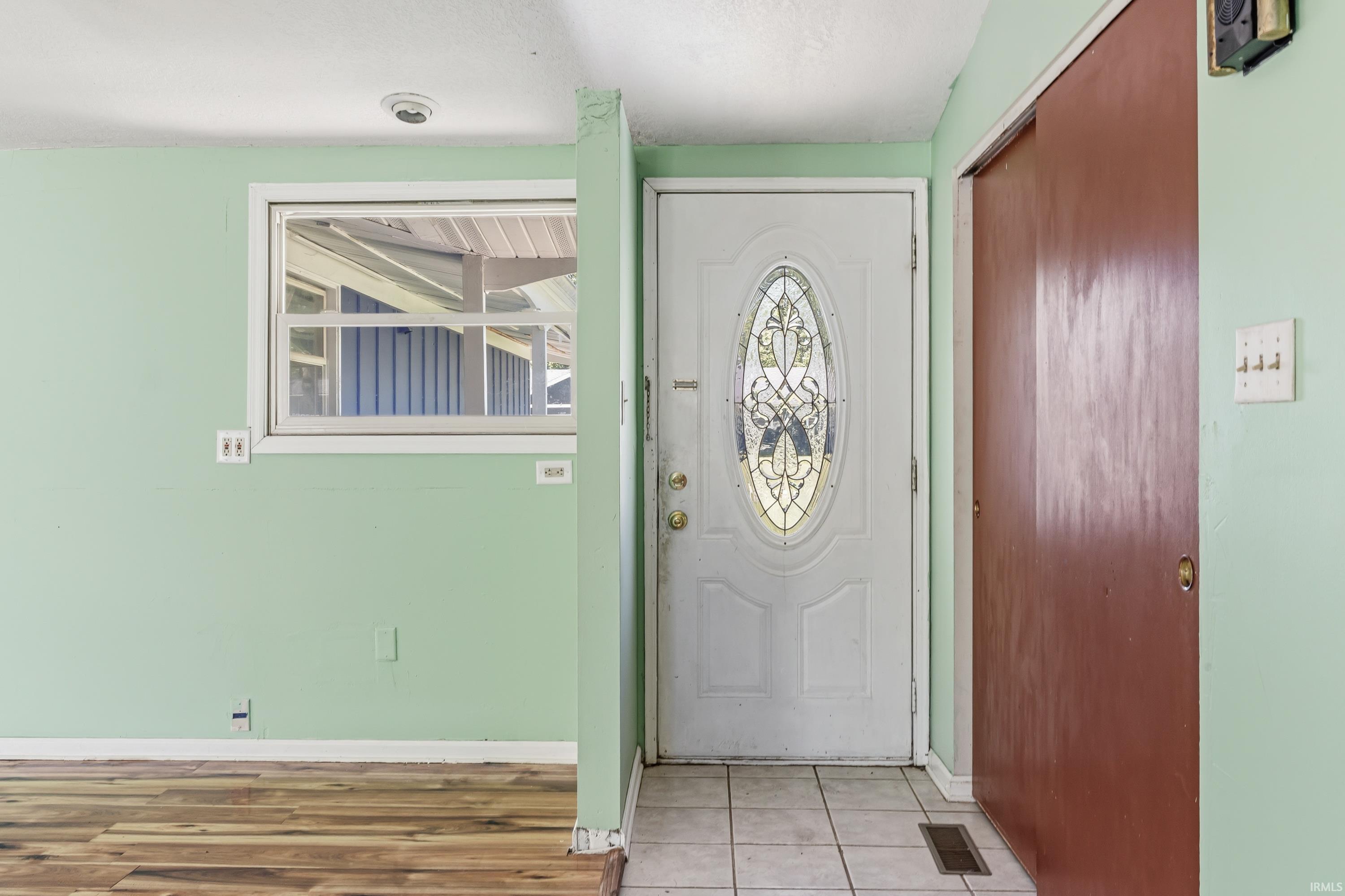 Entryway featuring a white door with decorative glass inserts