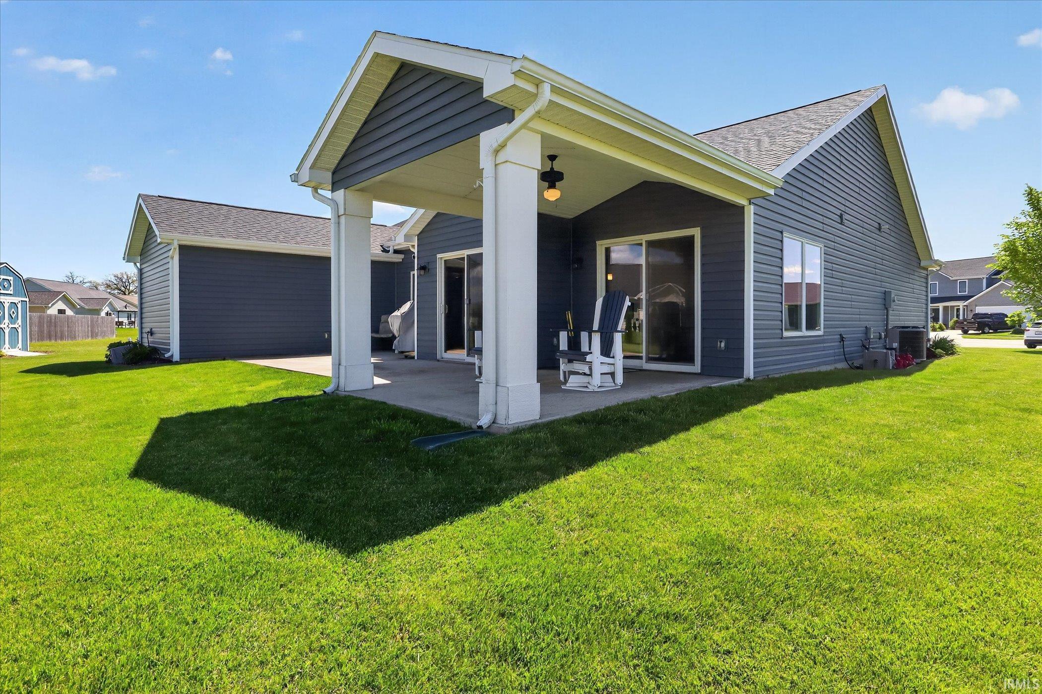 Rear exterior featuring a covered patio with concrete flooring, recessed lighting, and white support columns