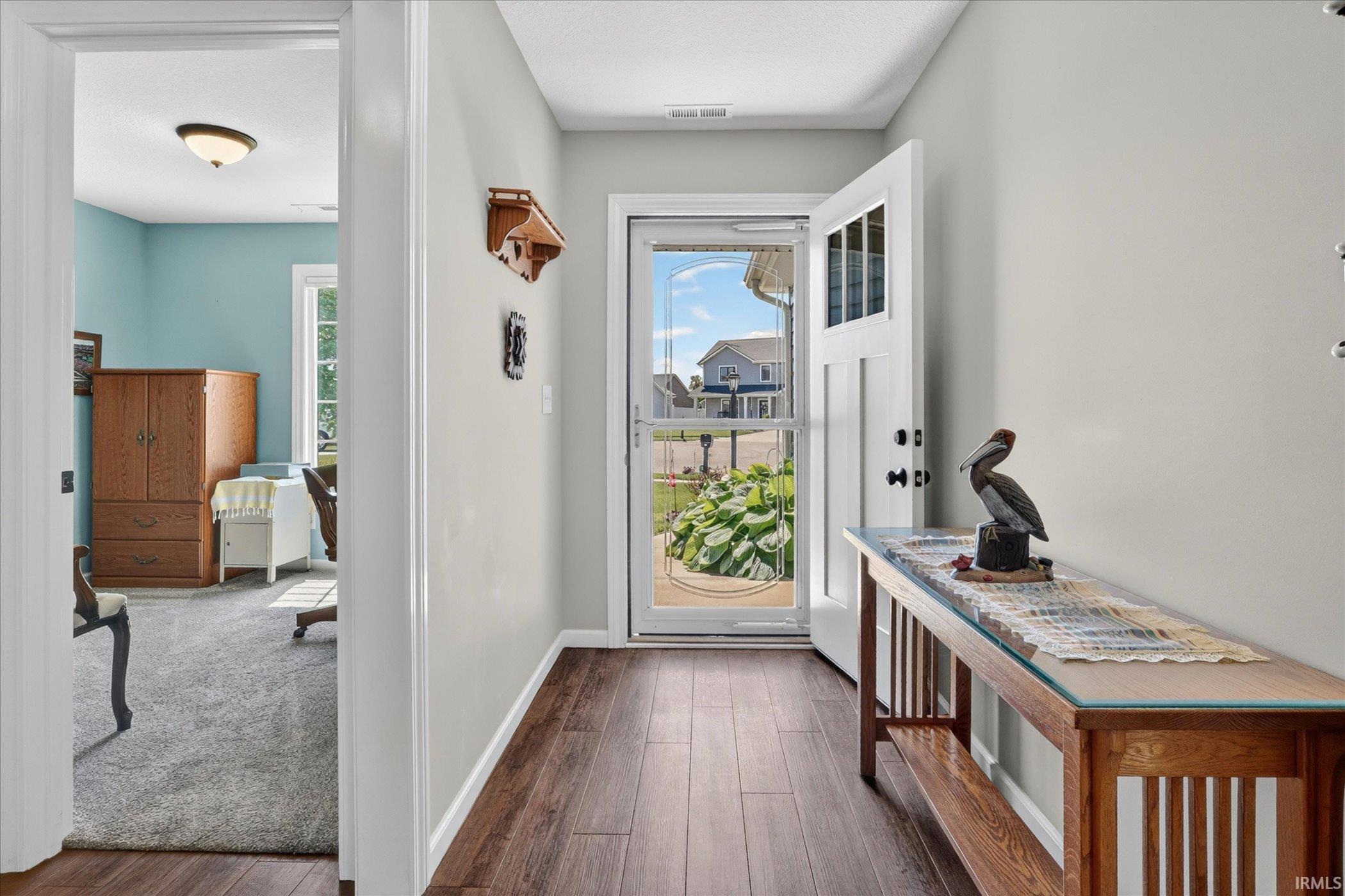 Entryway featuring wood-finish flooring and a white paneled door with glass inserts