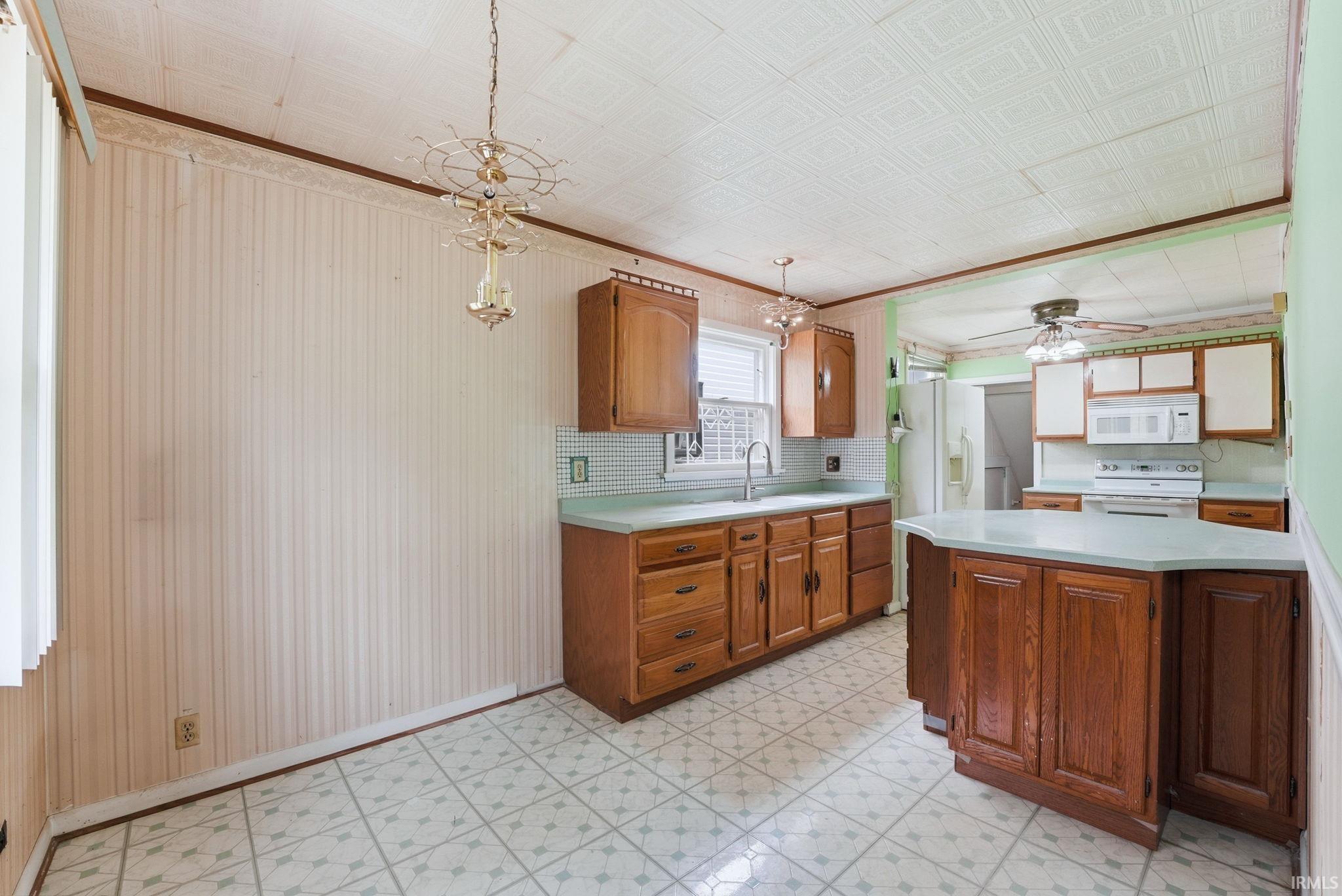 Kitchen featuring wood cabinetry, a central island with countertop, and an integrated double-basin sink