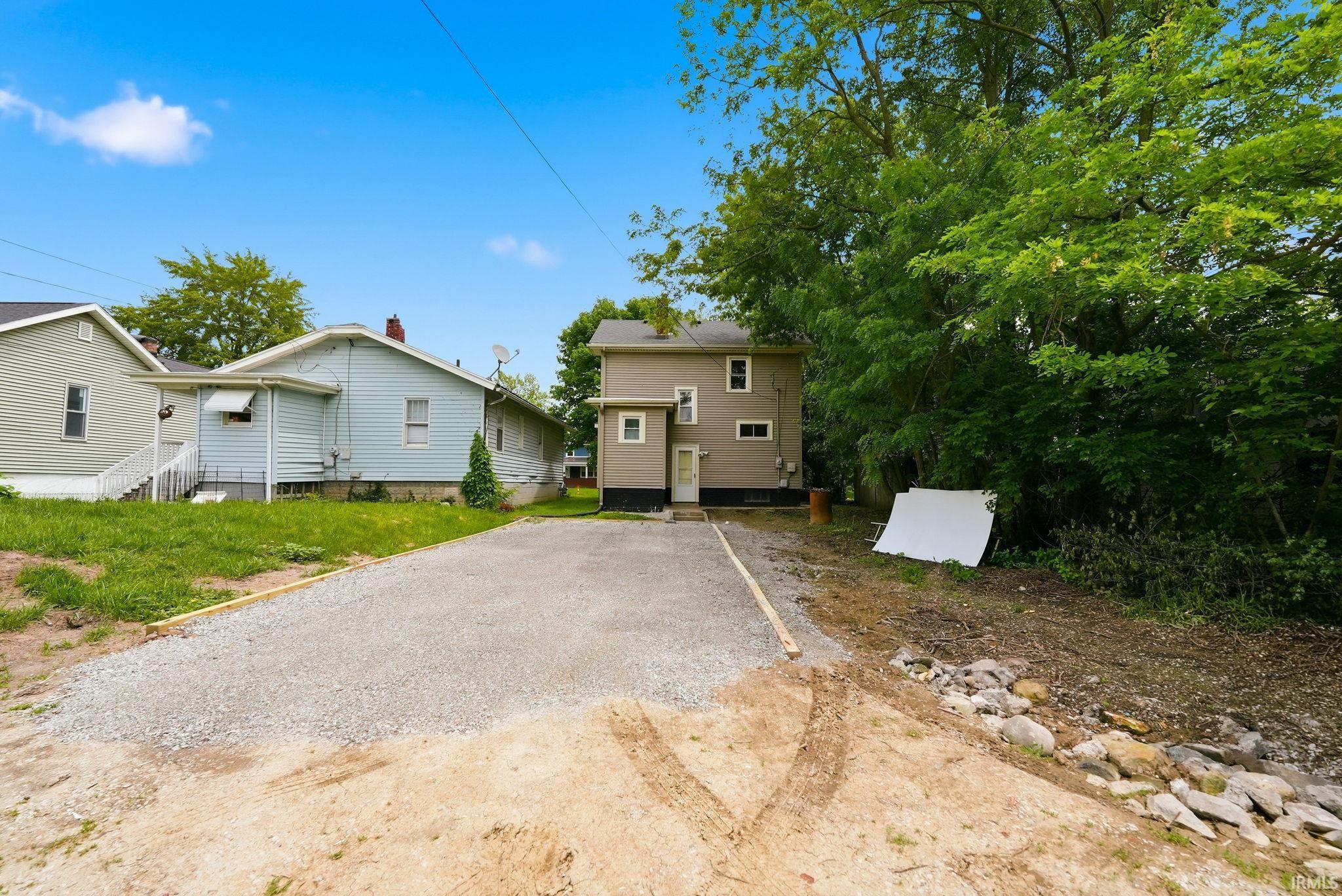 Gravel driveway leading to the rear entrance of the property