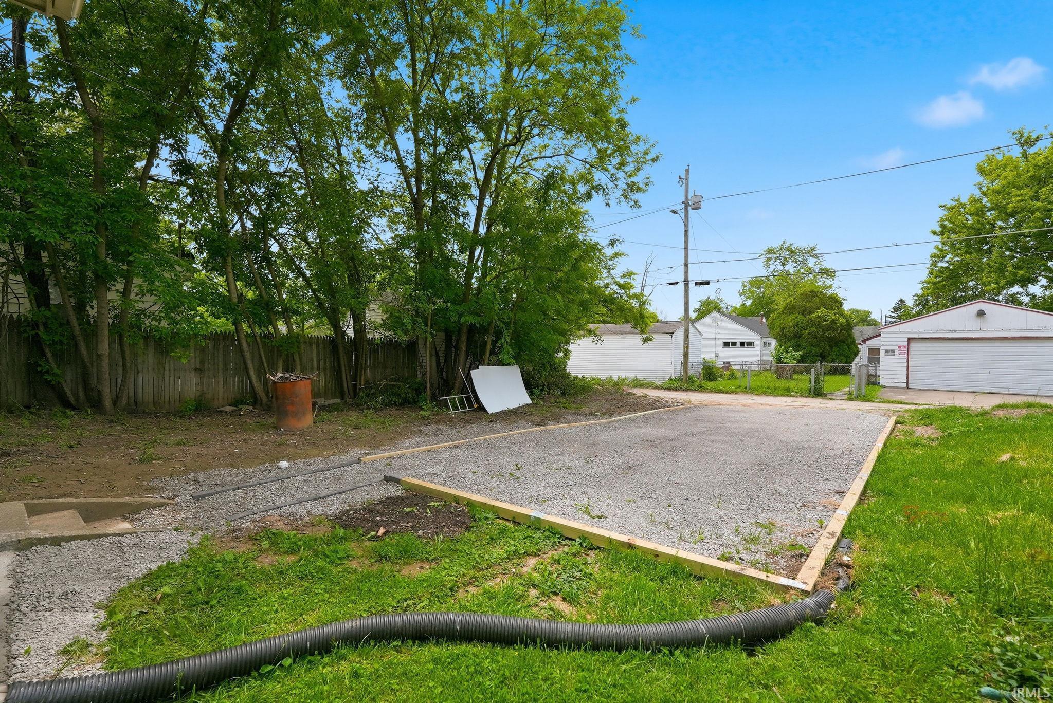 Spacious gravel pad framed with lumber, accompanied by a gravel path and grassy areas