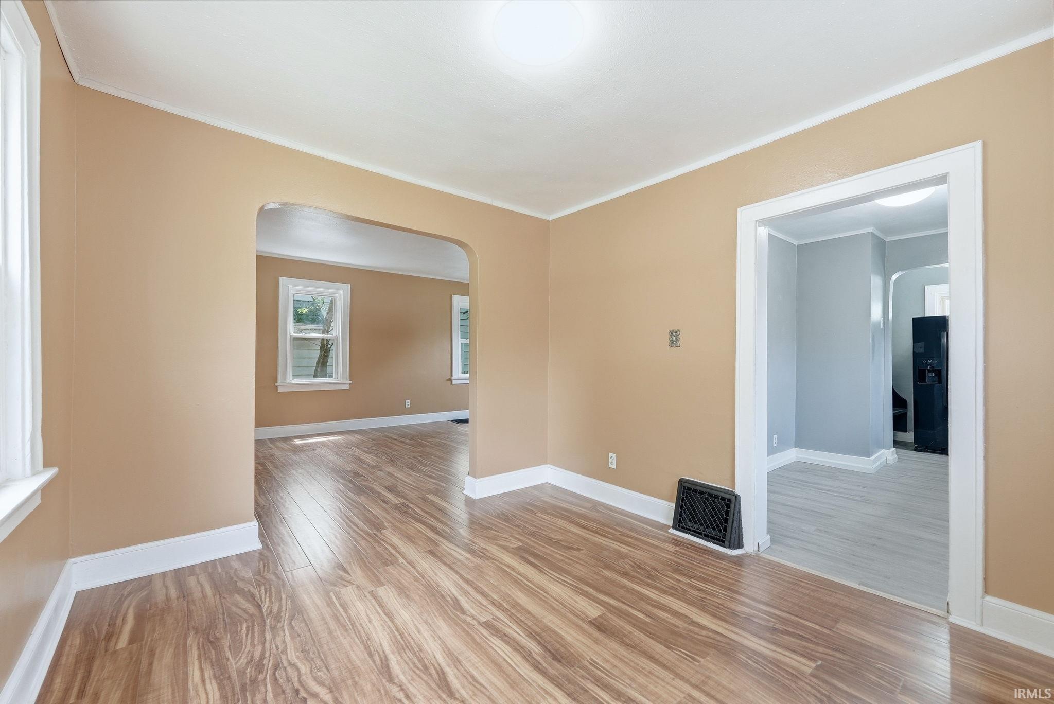Interior space featuring wood-finish flooring, light-colored walls, white trim, and a recessed ceiling light