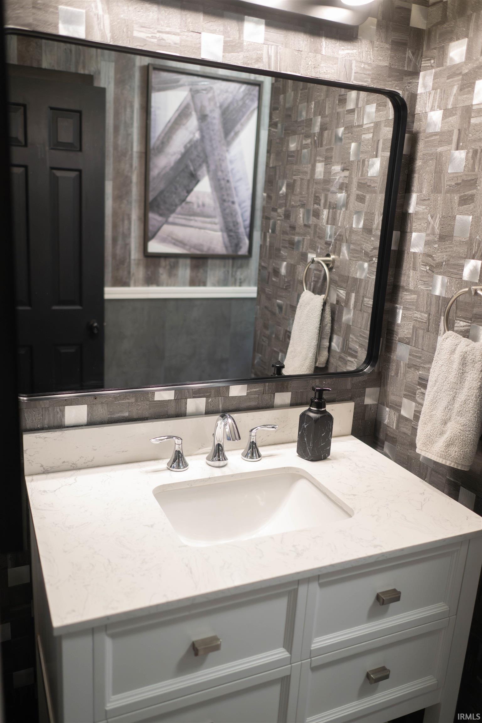 White vanity with a rectangular undermount sink and polished chrome faucet