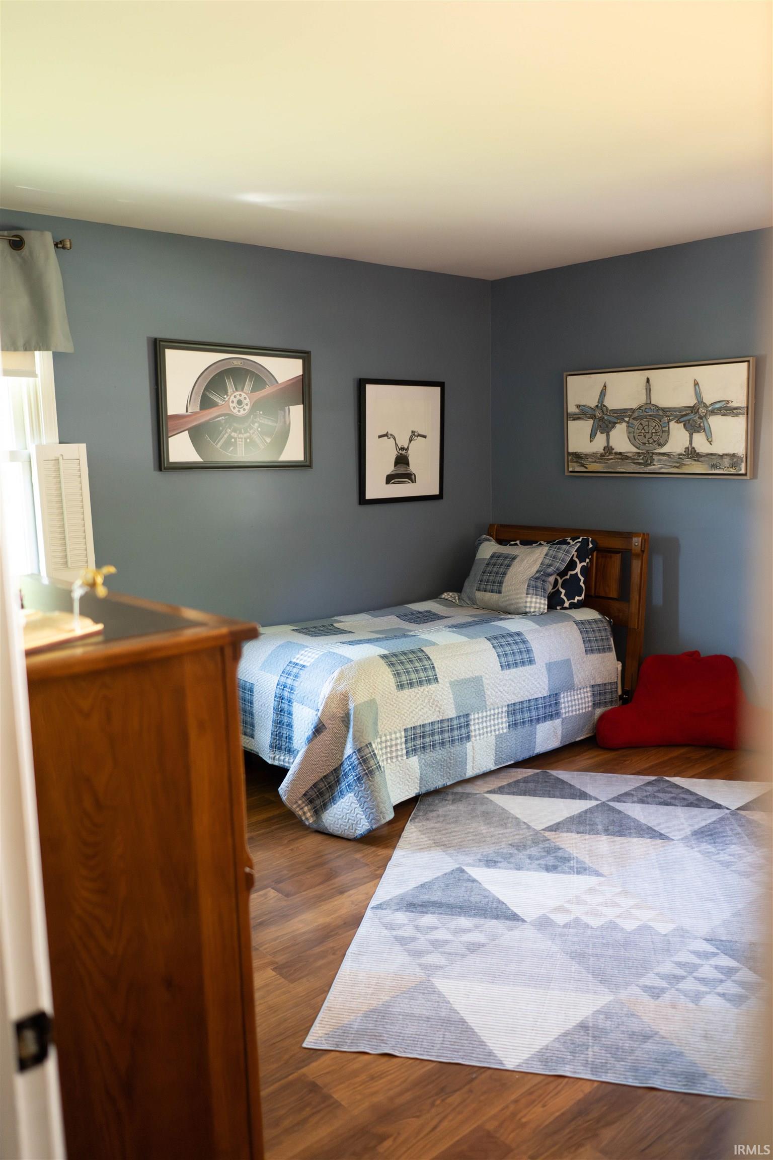 Hardwood-finish flooring complements the neutral wall color of this bedroom