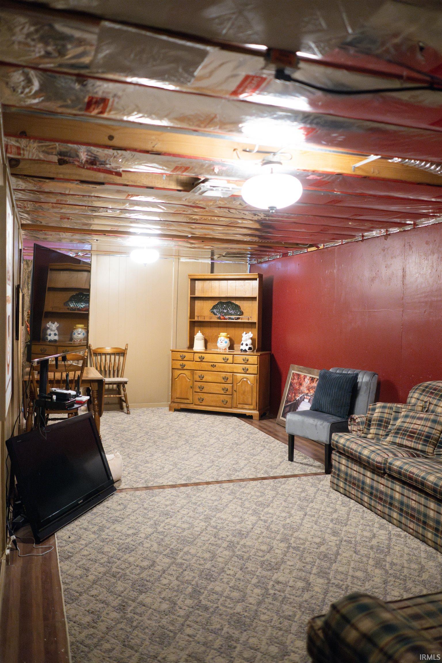 Expansive lower level featuring exposed ceiling joists and bright overhead lighting
