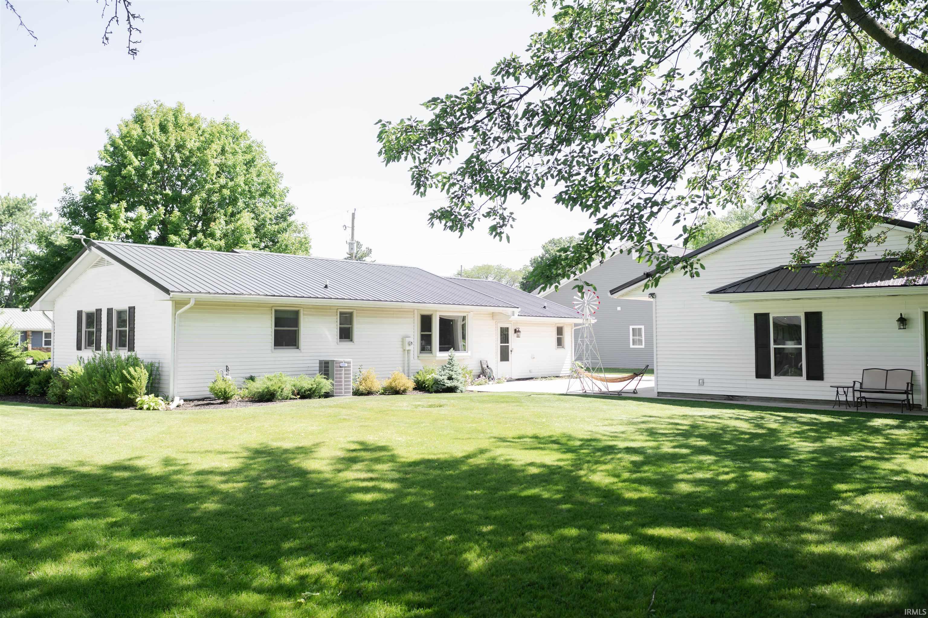 Expansive green lawn with mature trees and a detached structure