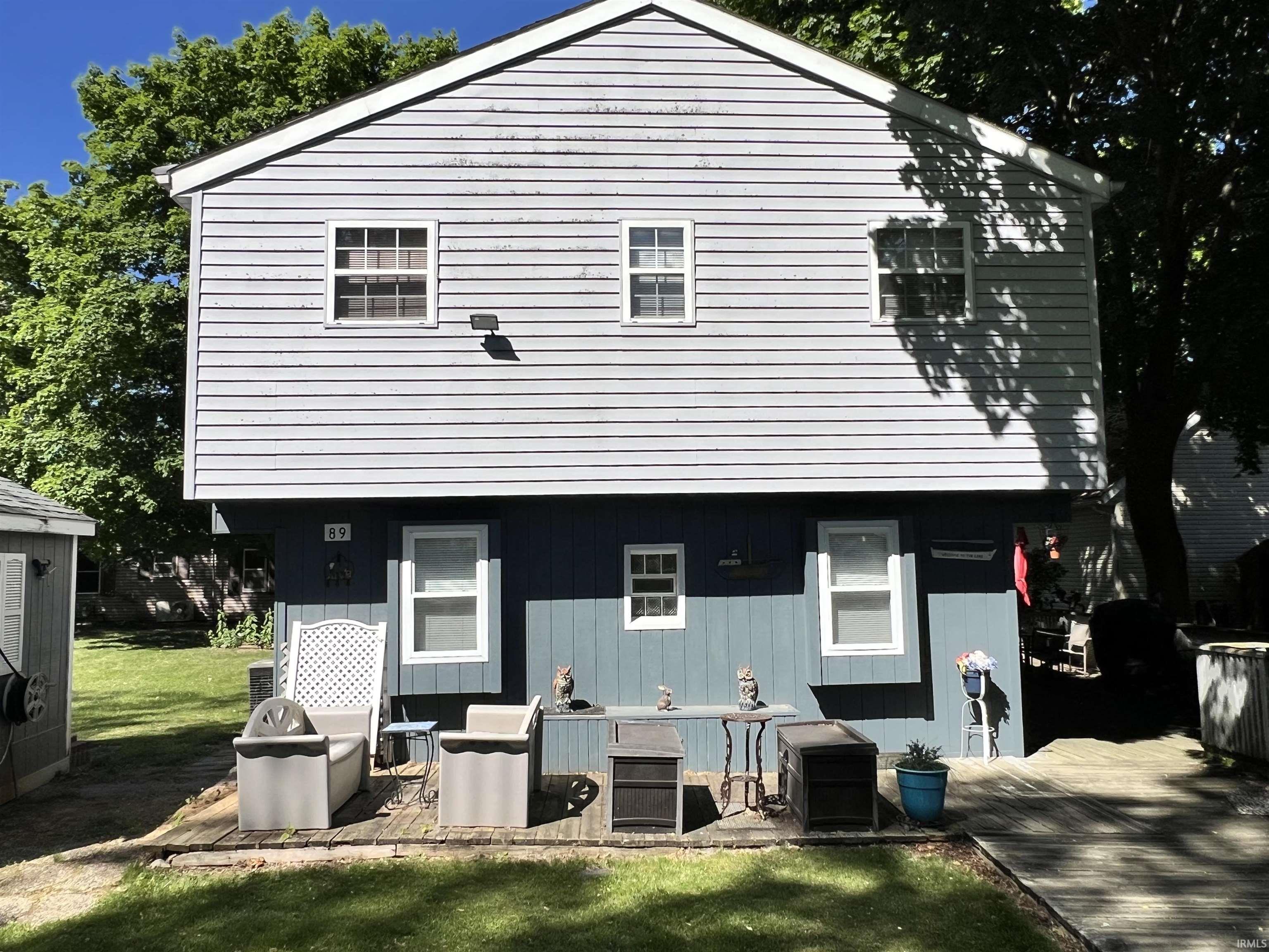 Two-story residence featuring light blue siding on the upper level and a darker blue siding on the lower level