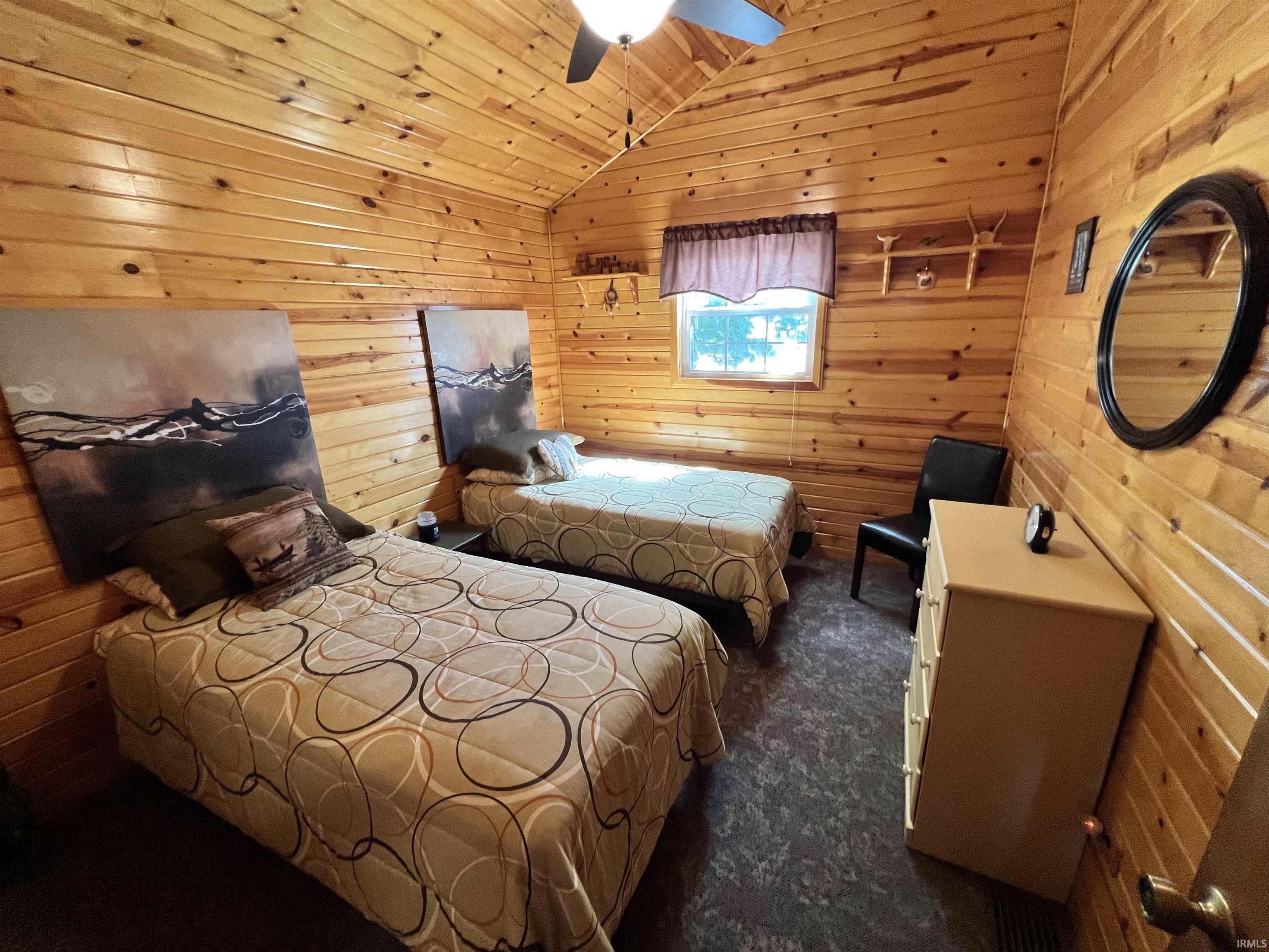 Interior room featuring wood-paneled walls and a vaulted ceiling
