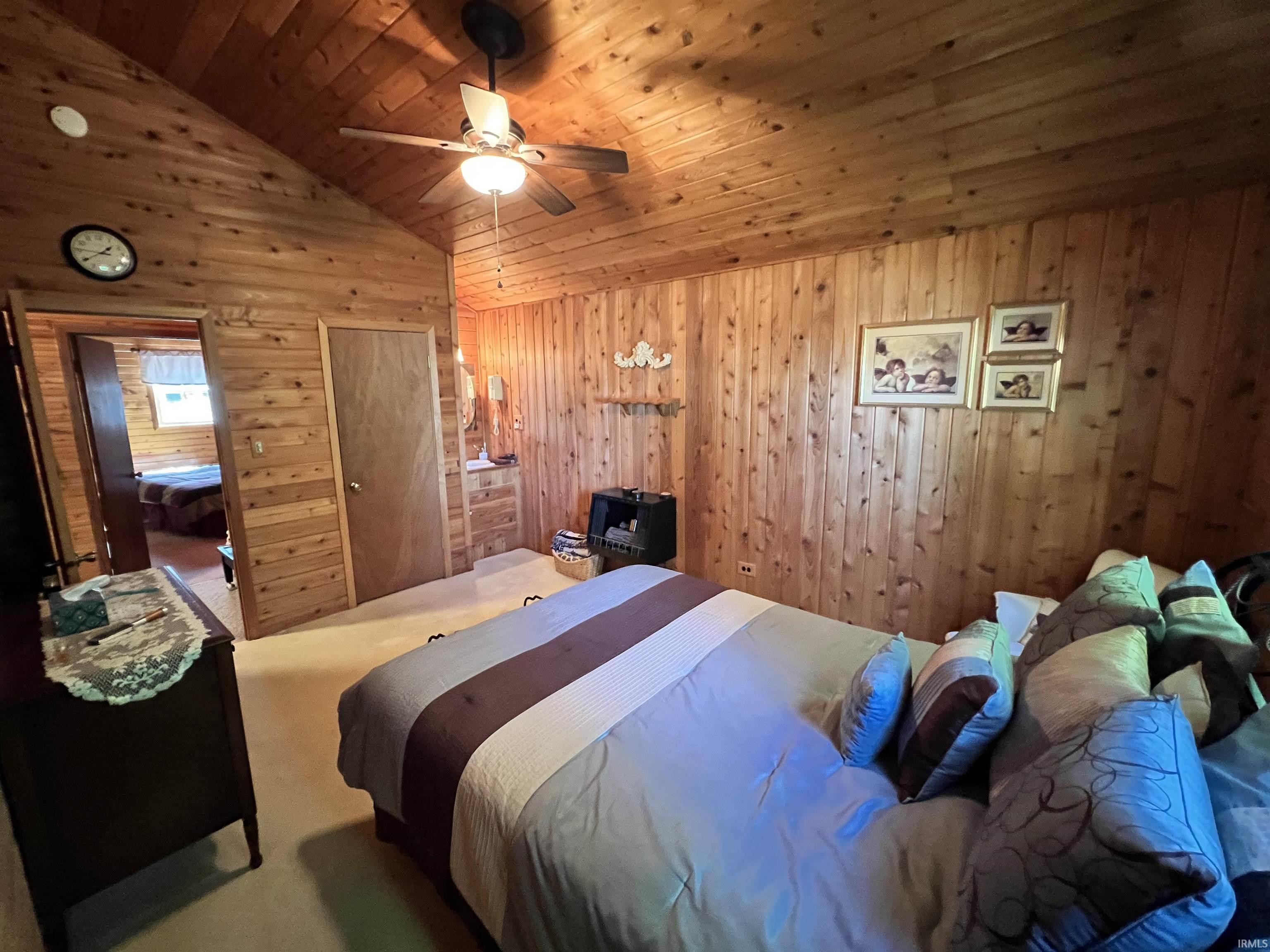 Vaulted wood-paneled ceiling with a central ceiling fan