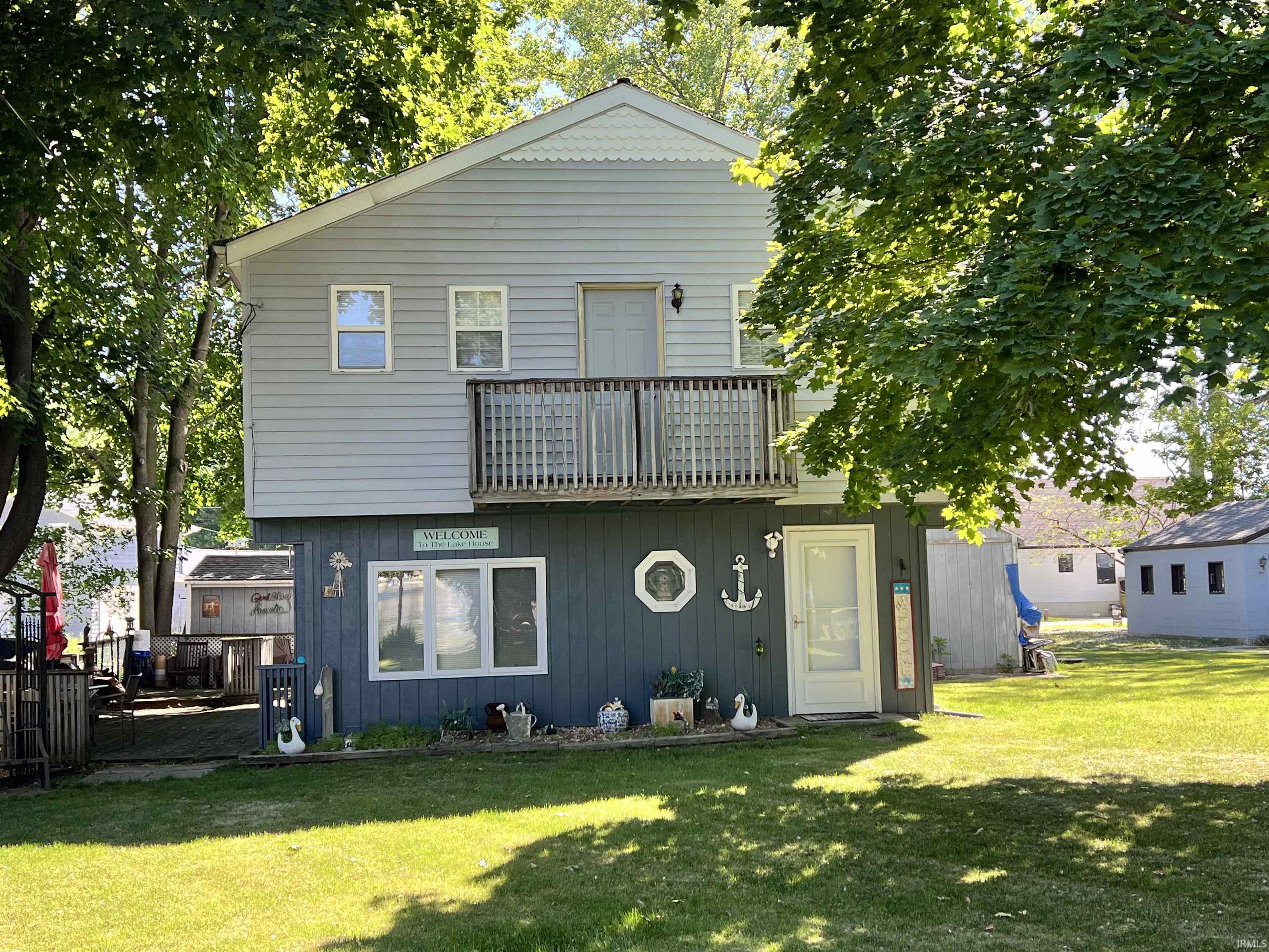 Two-story home featuring light blue siding on the upper level and dark blue siding on the lower level