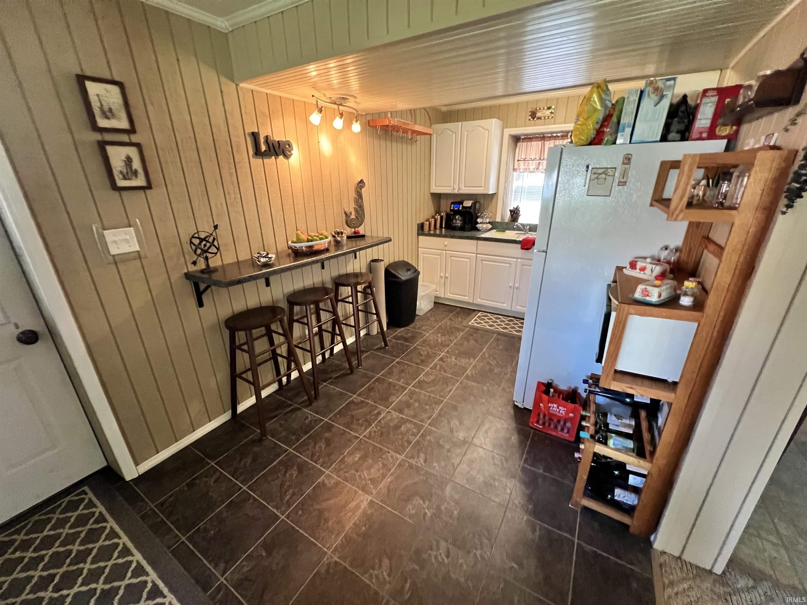 Kitchen featuring white cabinetry, dark countertop, and tiled flooring