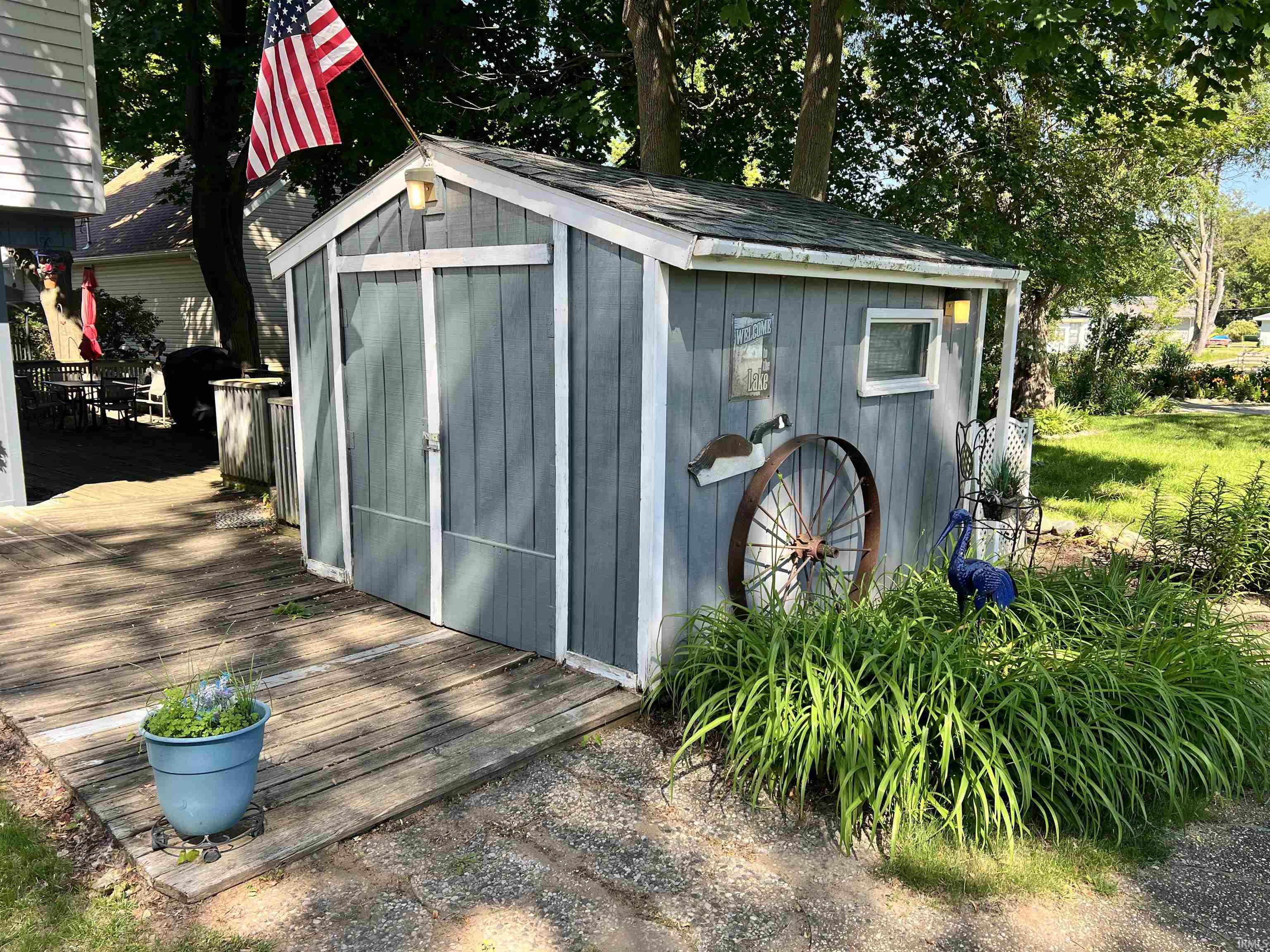 Gray storage shed with white trim, featuring a gable roof and a small window