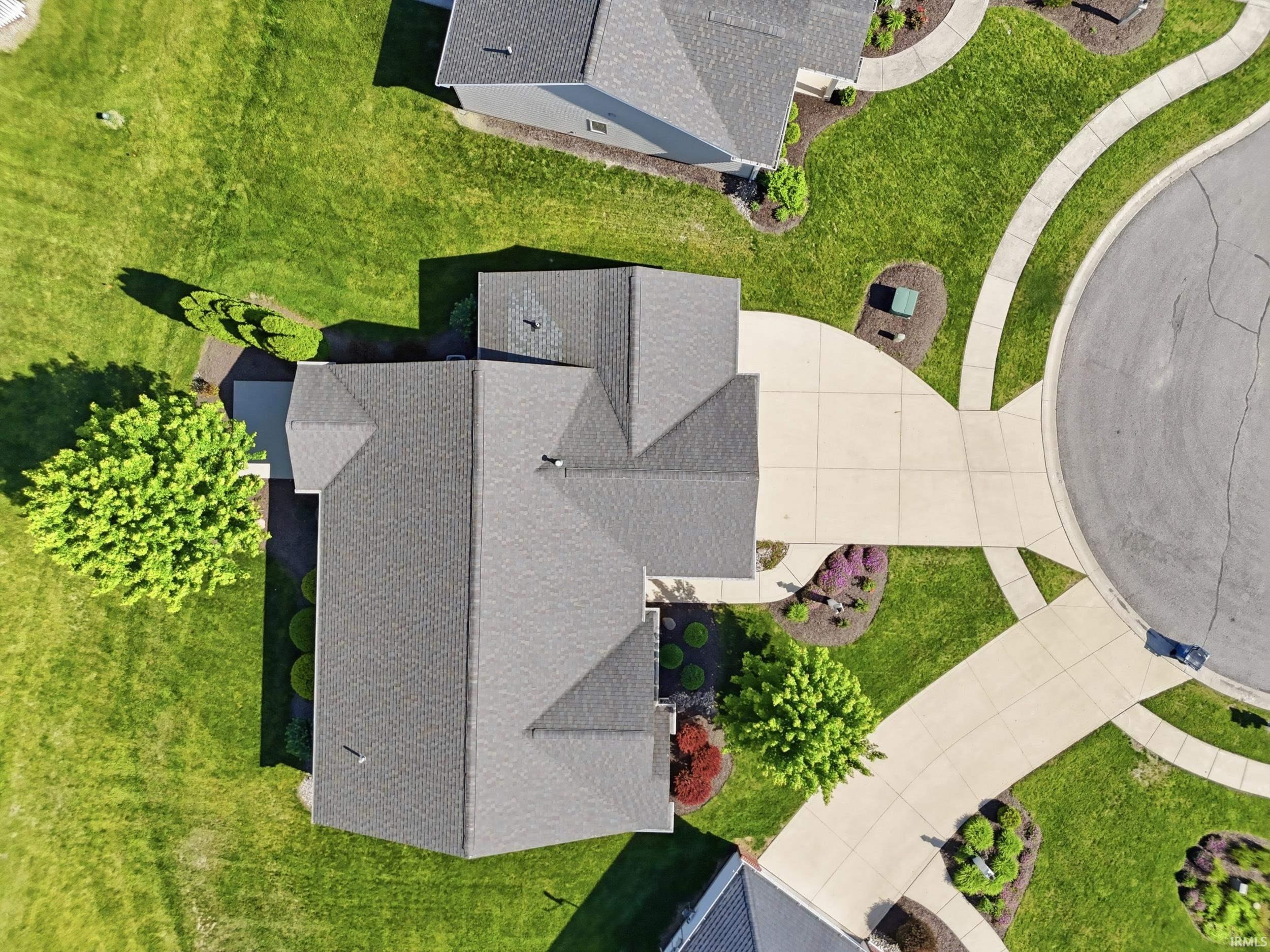 Overhead view of a residential property featuring a multi-gabled roofline with dark shingles