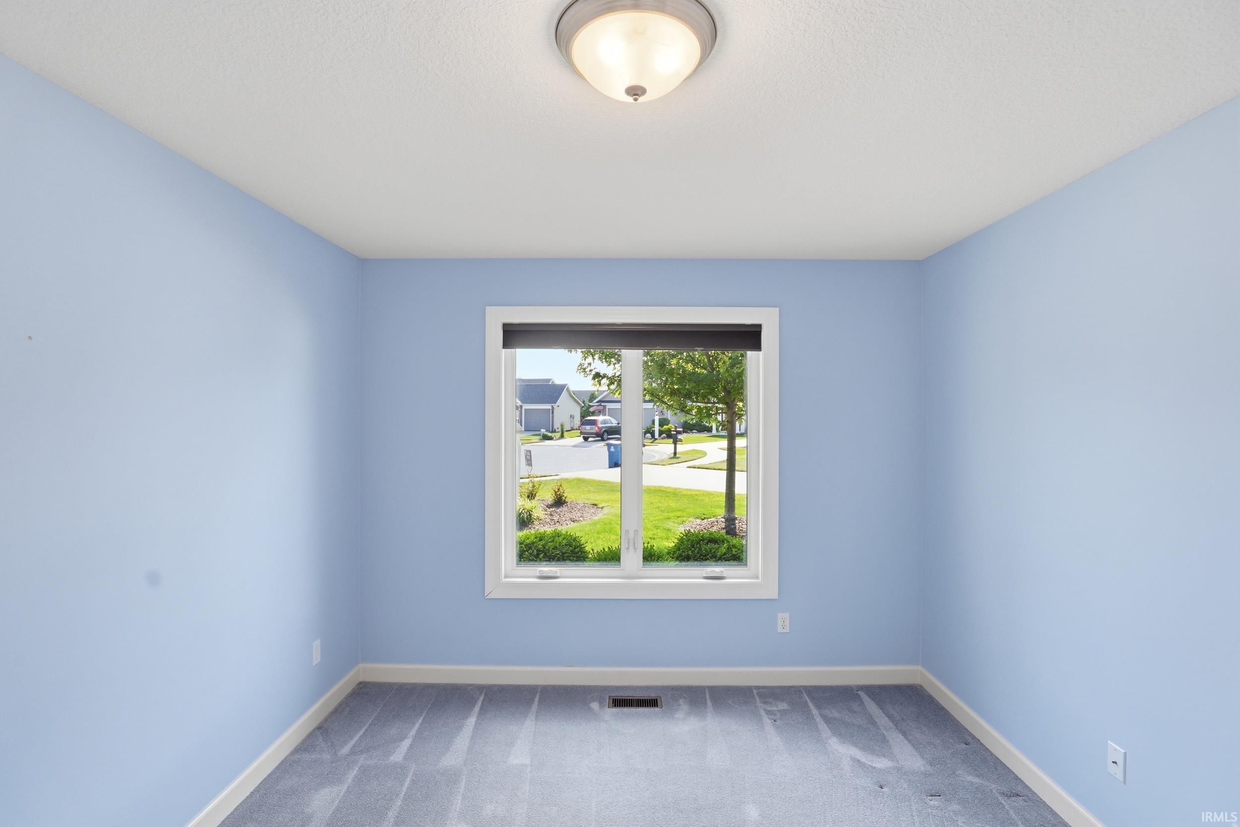 Room featuring light blue painted walls and gray patterned carpet