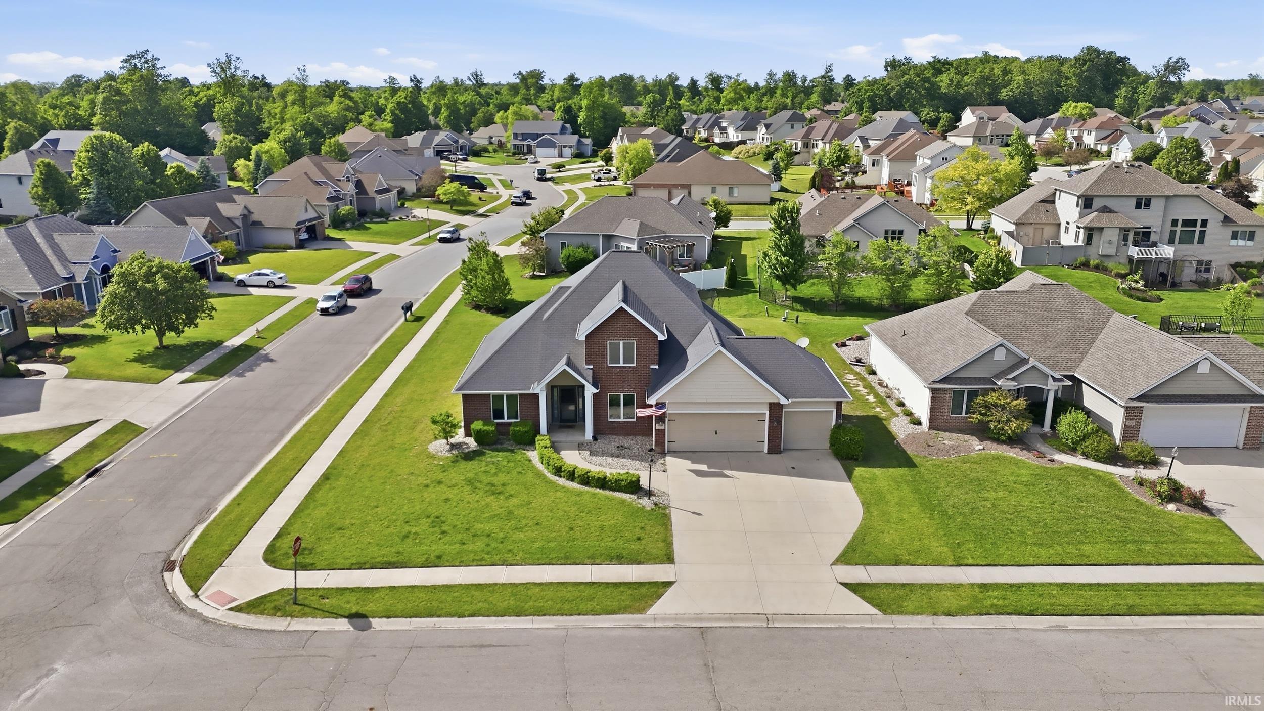 Traditional two-story residence featuring a brick facade, gabled roof, and attached two-car garage