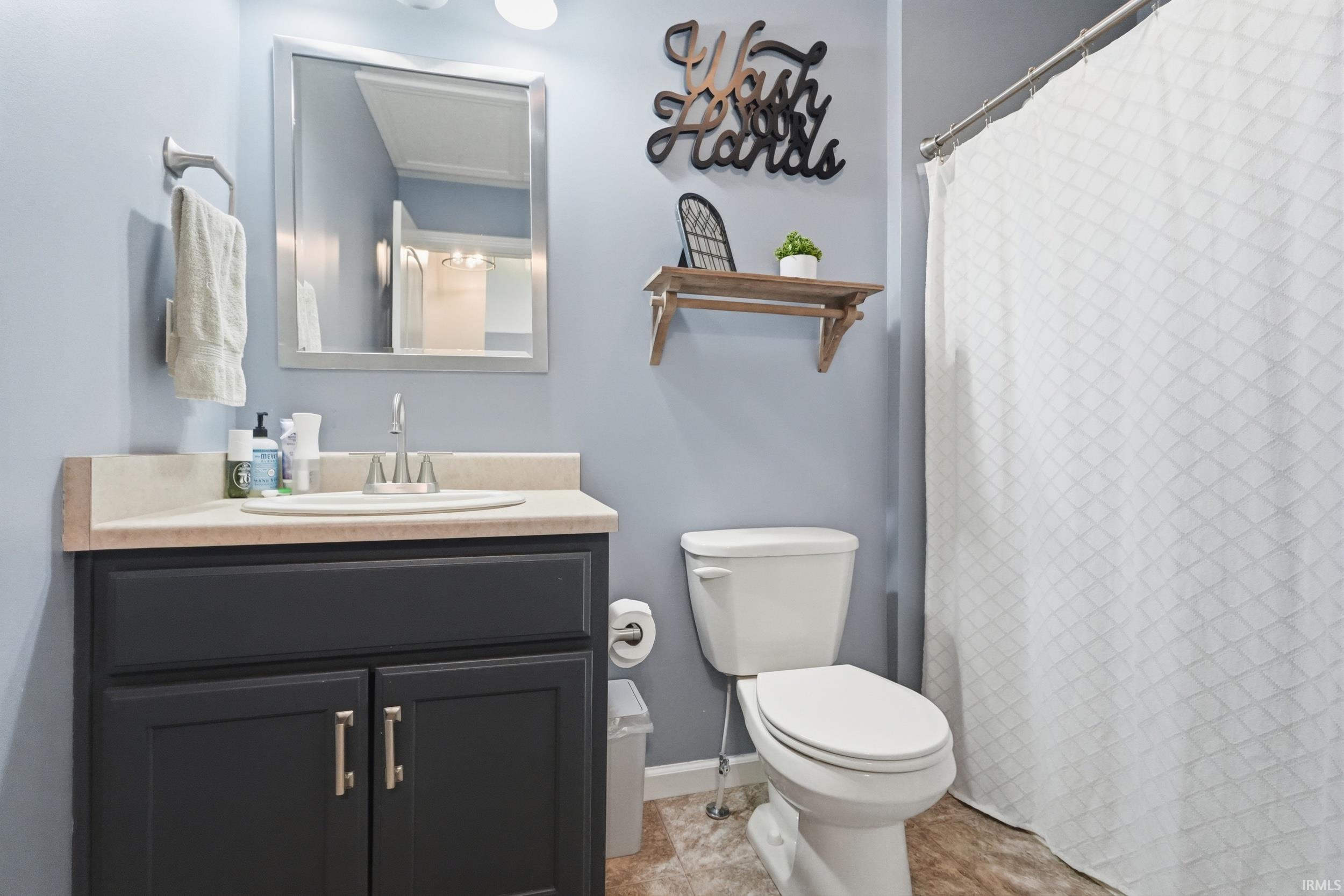 Bathroom featuring a dark wood vanity with a light-colored countertop and integrated sink