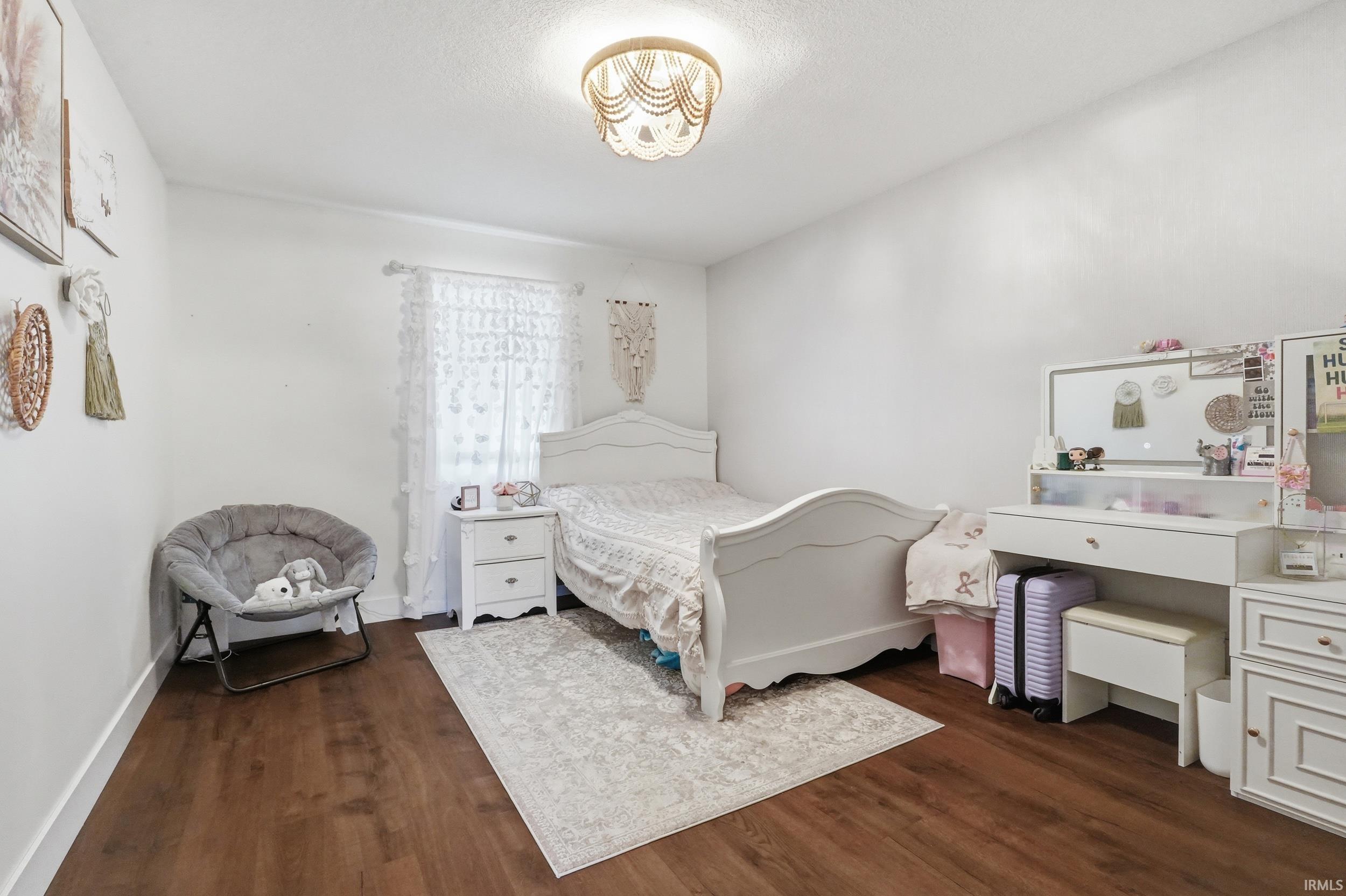 Wood-finish flooring throughout, featuring a window with natural light, and a ceiling-mounted light fixture