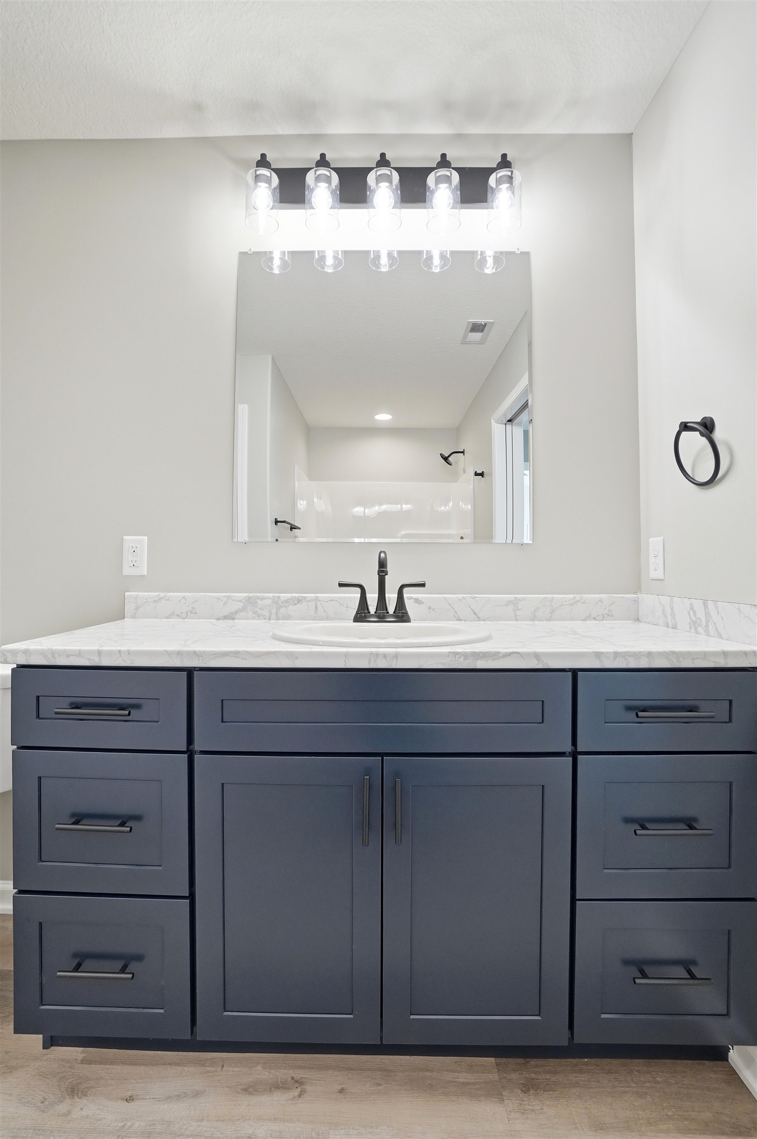 Bathroom vanity featuring a white marble-patterned countertop, an undermount sink, and a black faucet