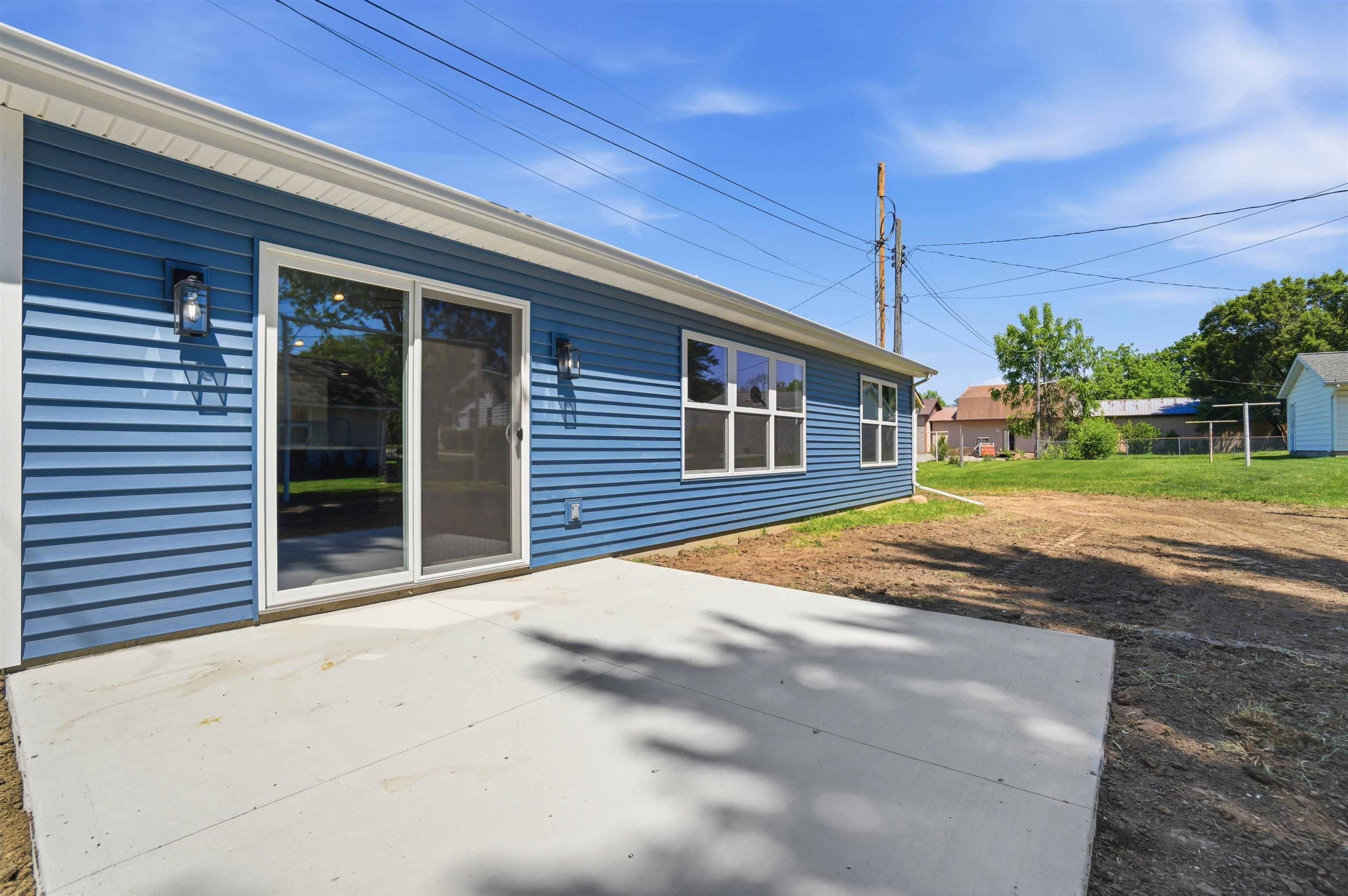 Expansive concrete patio with direct access to the interior via sliding glass doors
