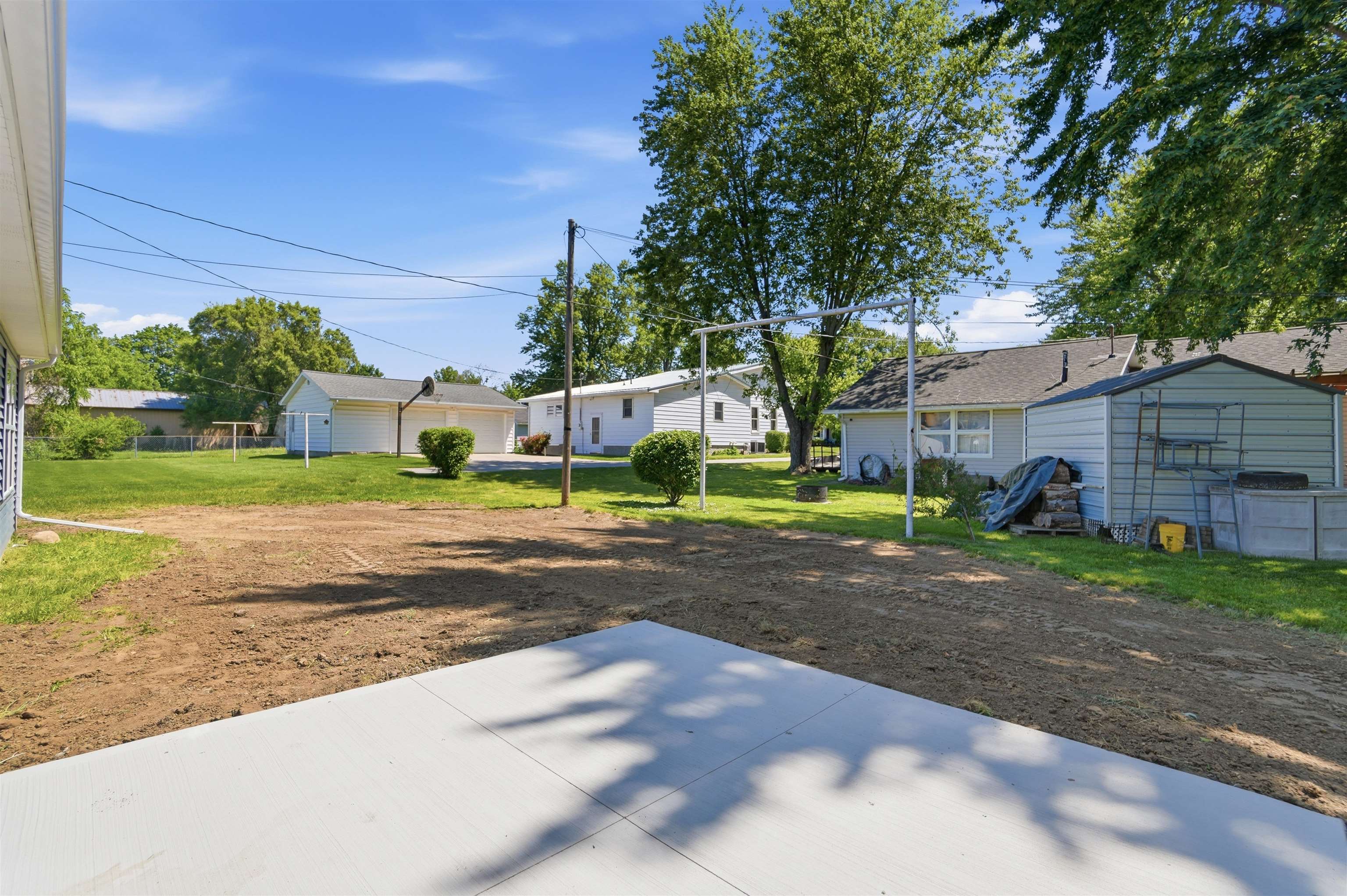 Expansive outdoor concrete patio with a large, cleared yard area