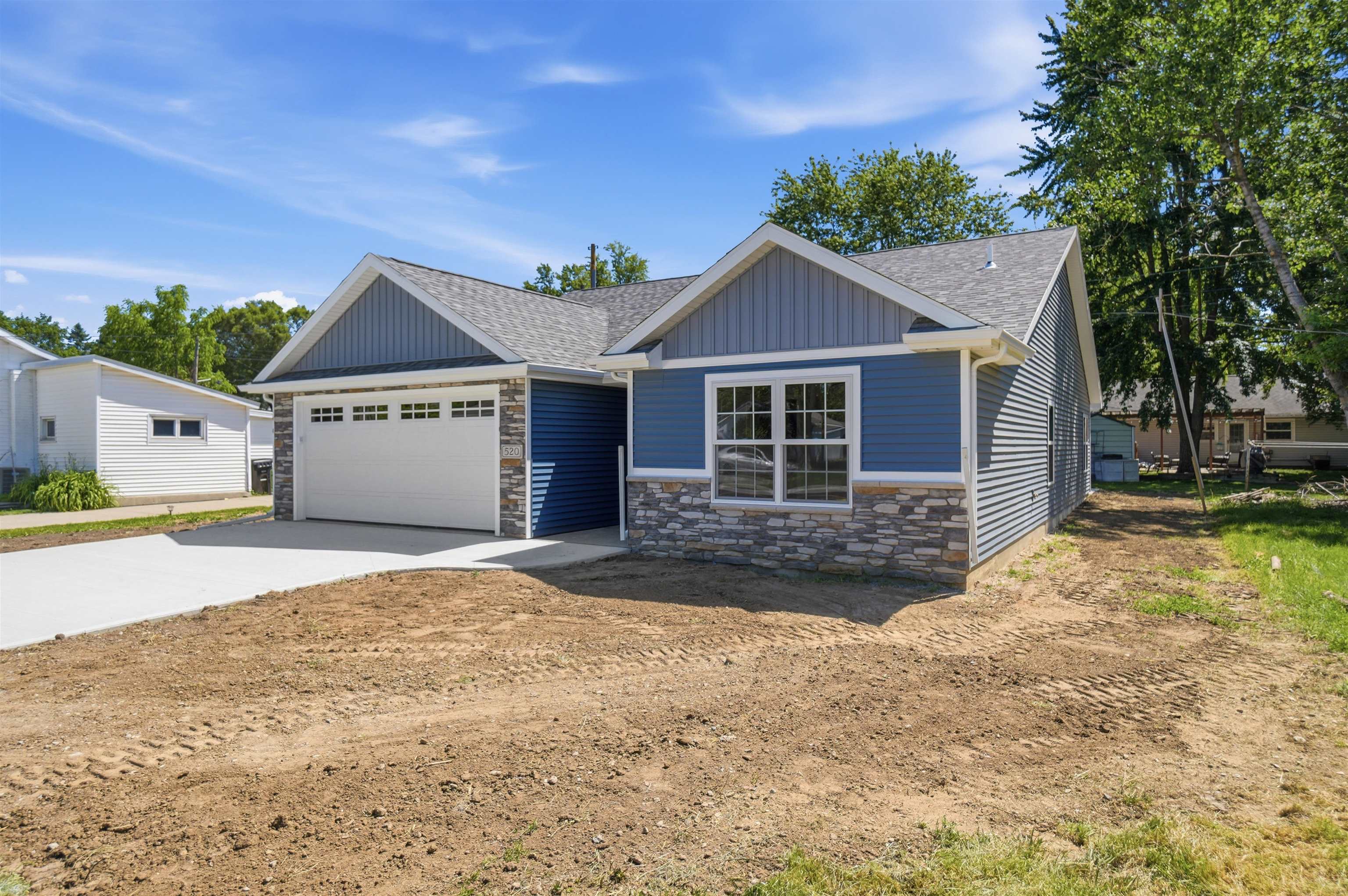 Contemporary residence featuring blue siding, white trim, and a stone facade